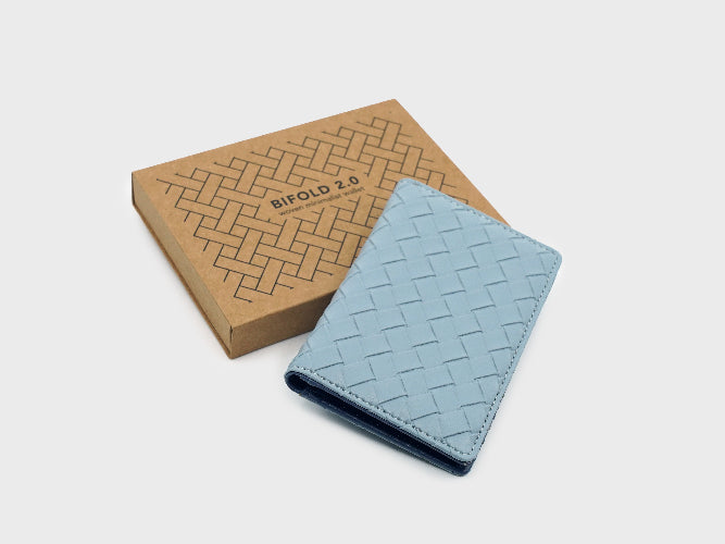 Blue woven wallet with a matching box on a light gray background