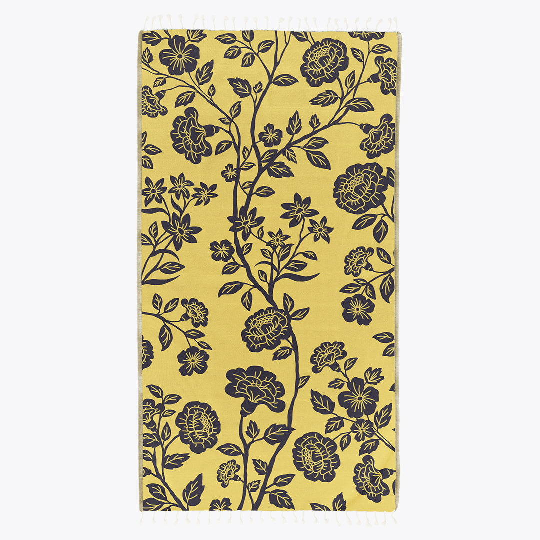 Yellow towel with black floral pattern on a white background