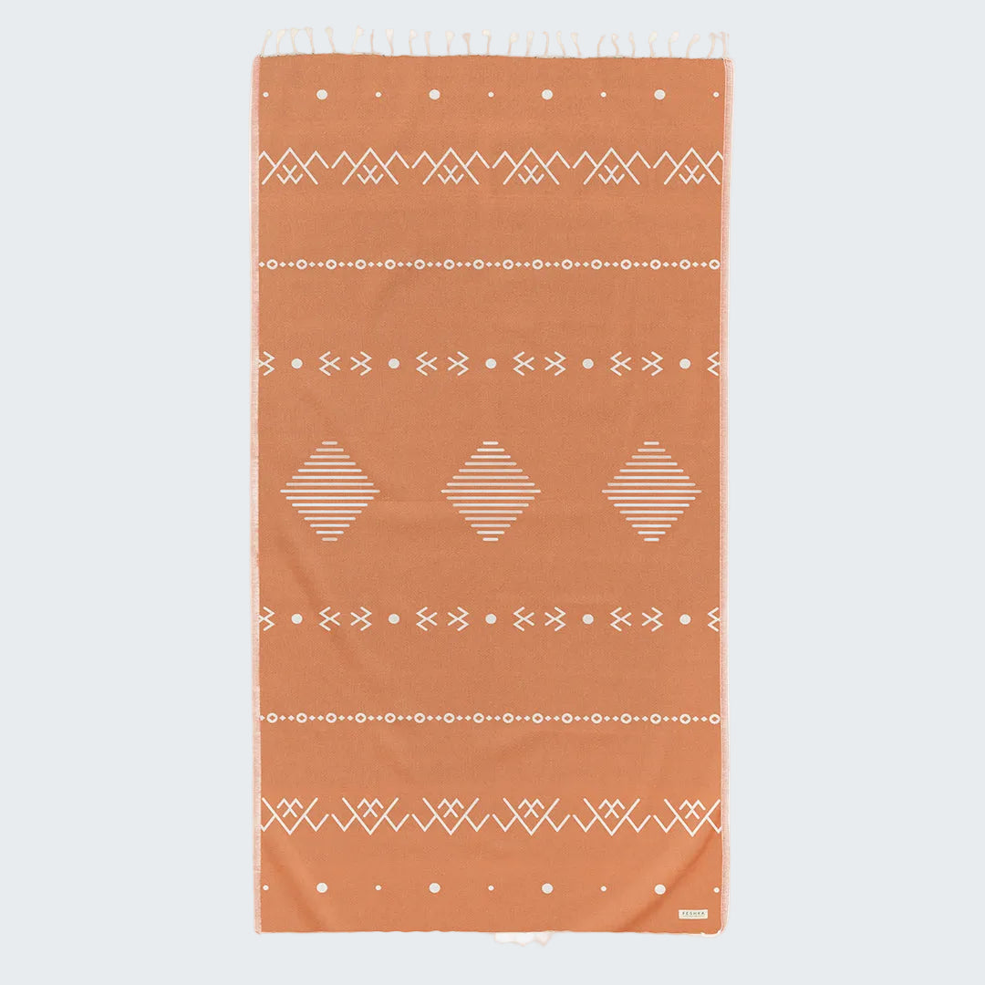 Orange towel with white geometric patterns on a white background