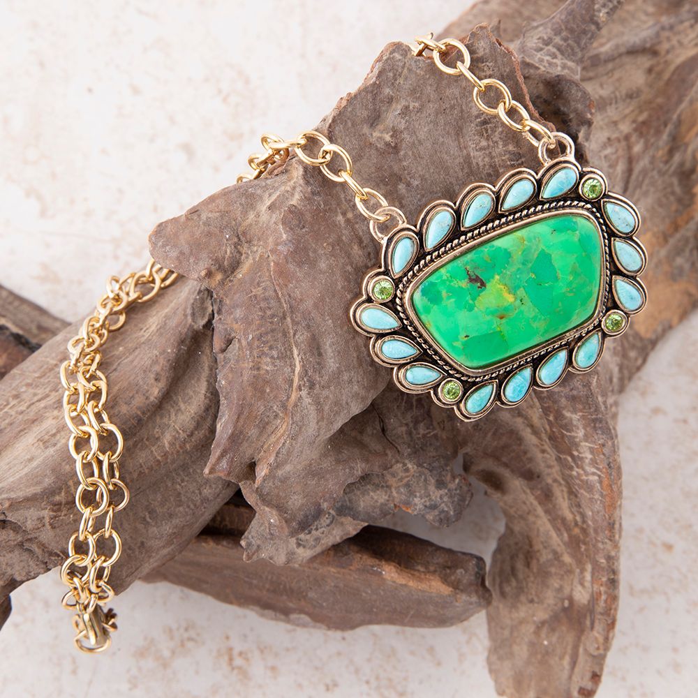 Necklace with a green stone pendant on a rock background