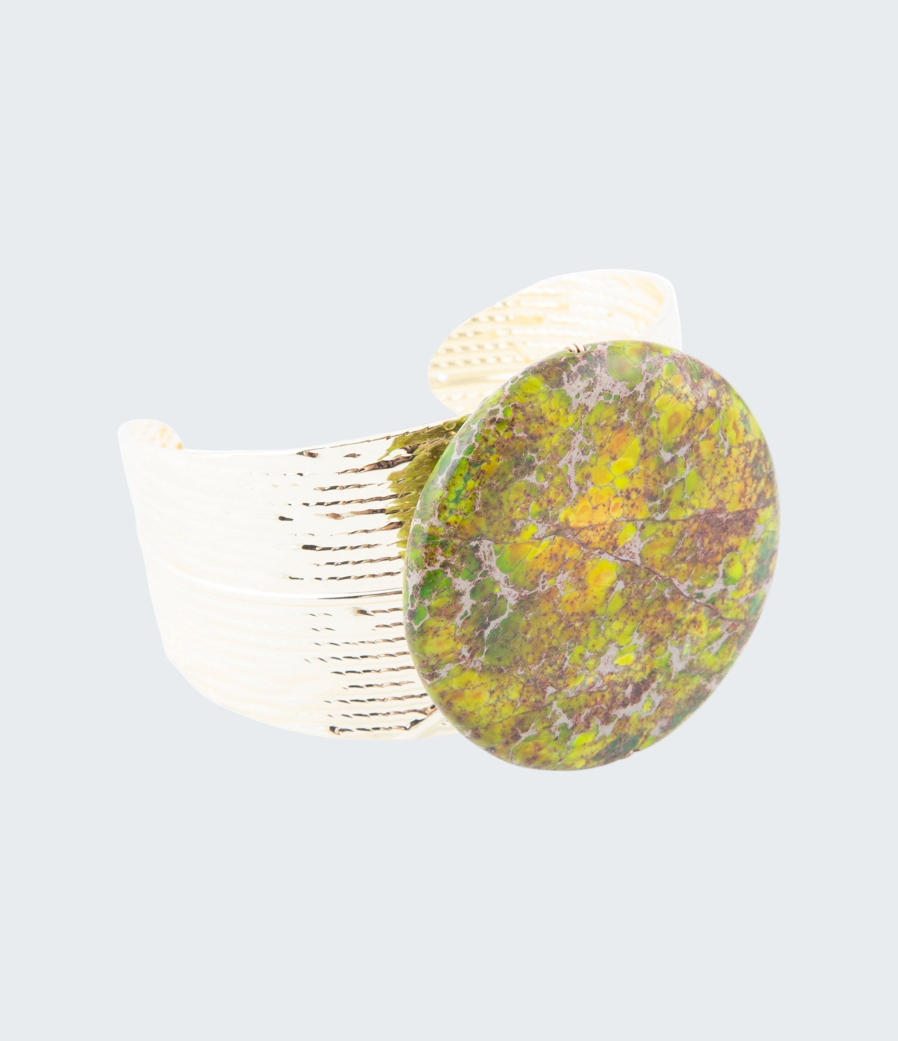 Ring with a green marbled stone on a white background