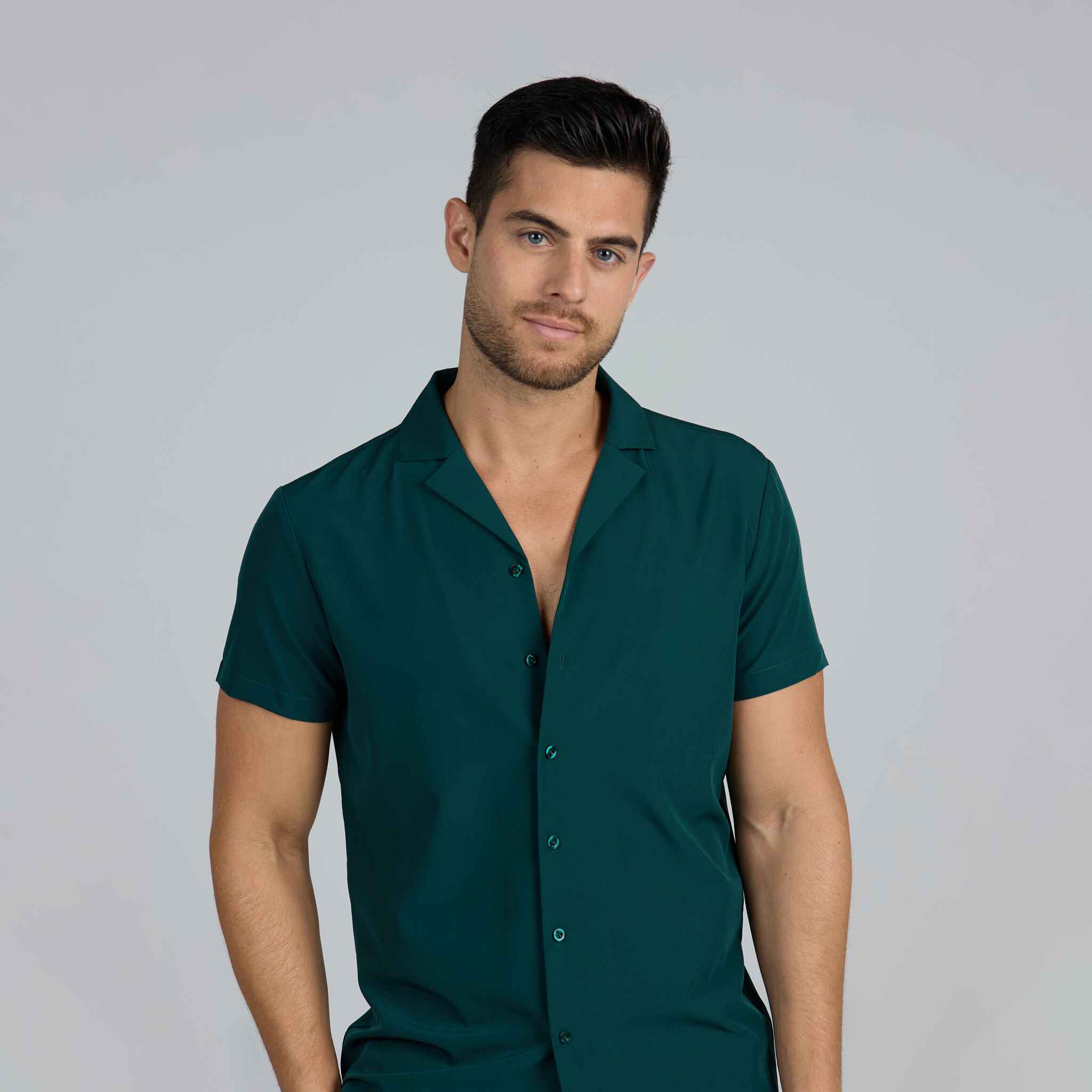 Man wearing a dark green shirt against a plain background