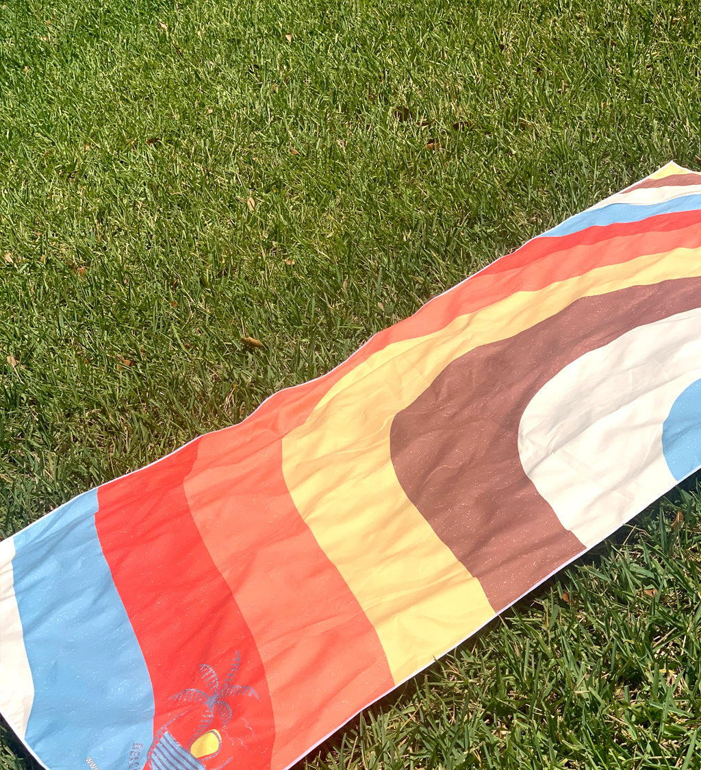 Colorful quilt with abstract patterns on a grassy background