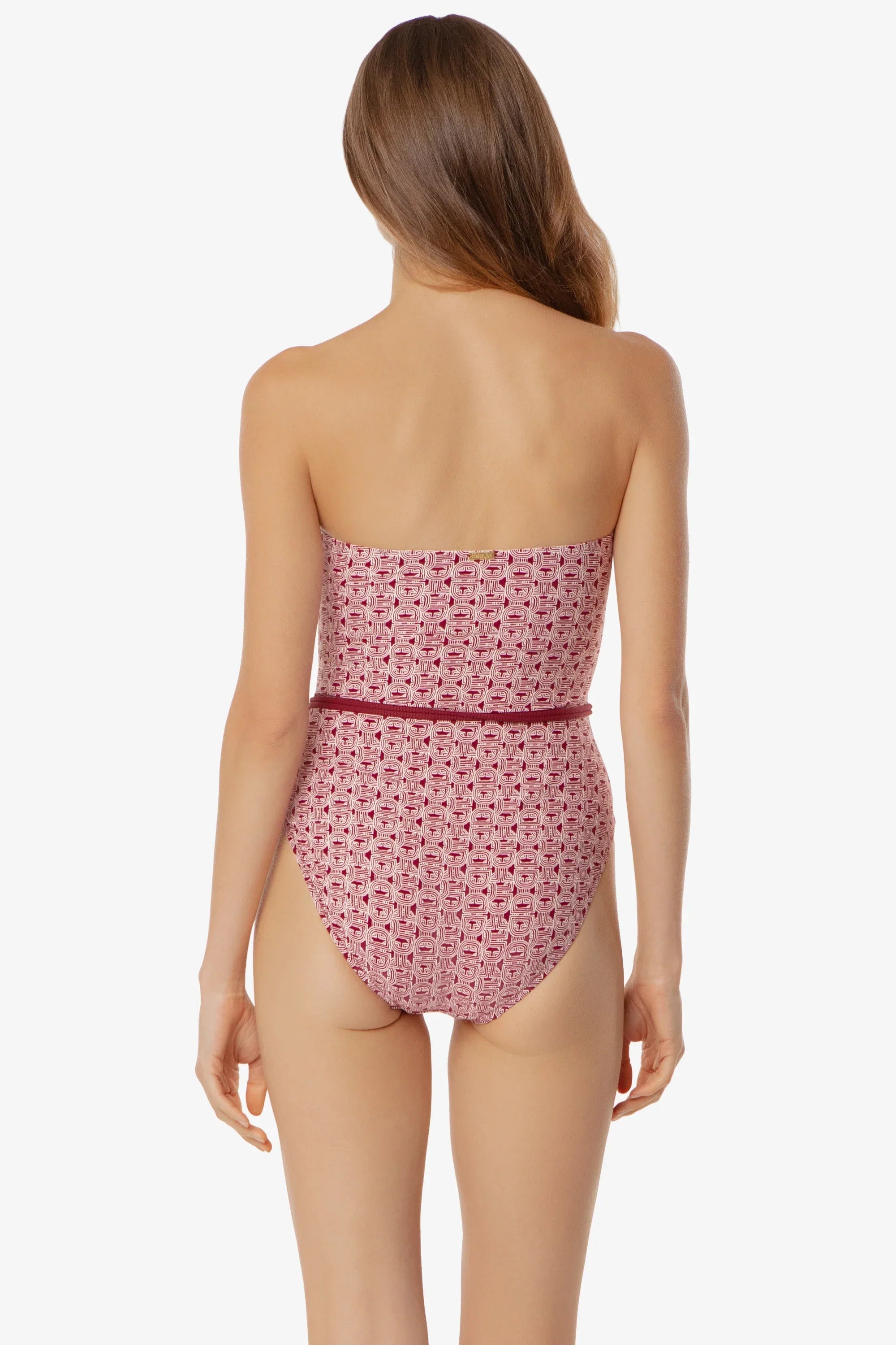Woman wearing a strapless pink swimsuit with a subtle pattern on a white background