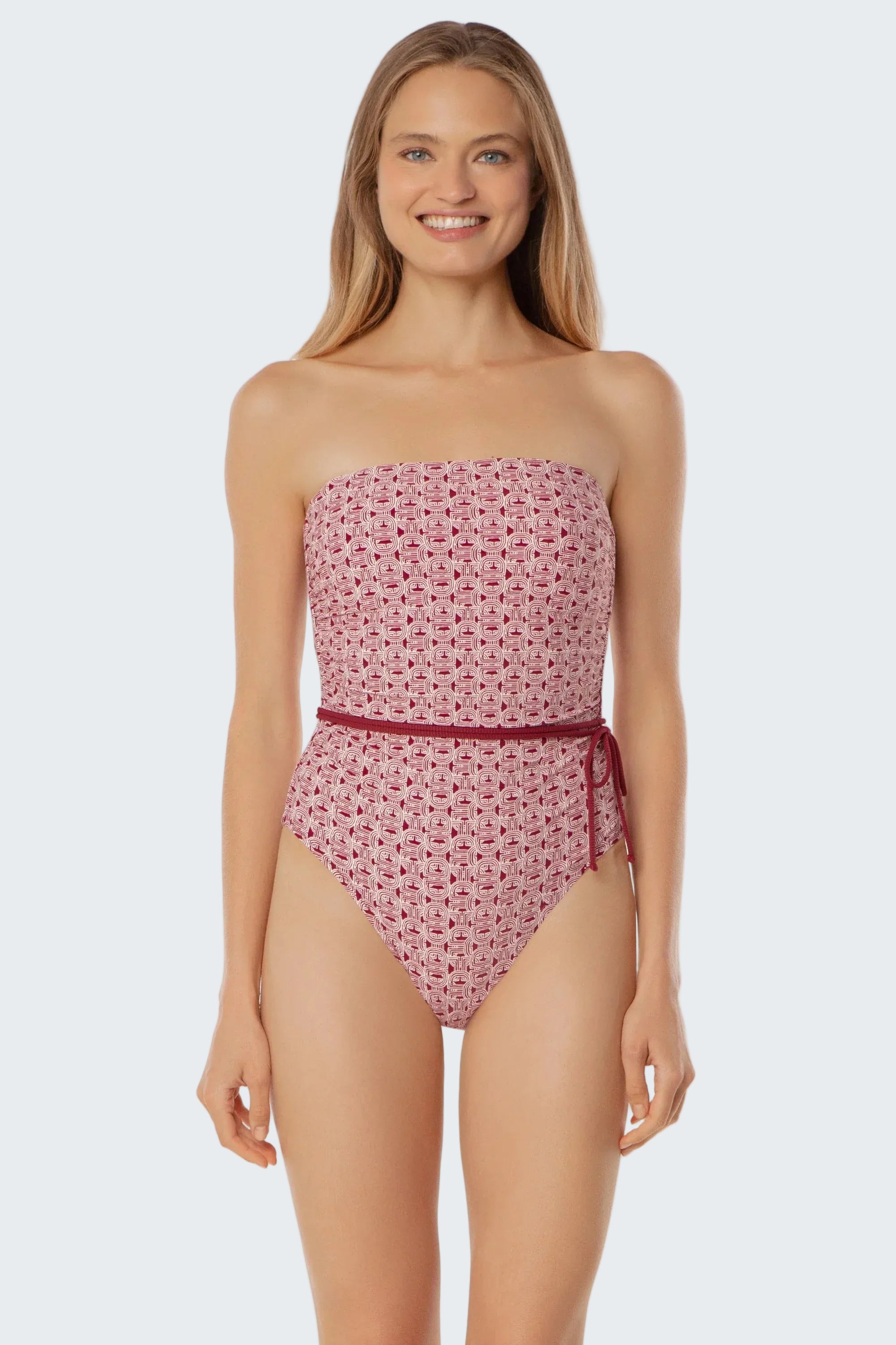 Woman wearing a pink strapless swimsuit with a subtle pattern on a white background