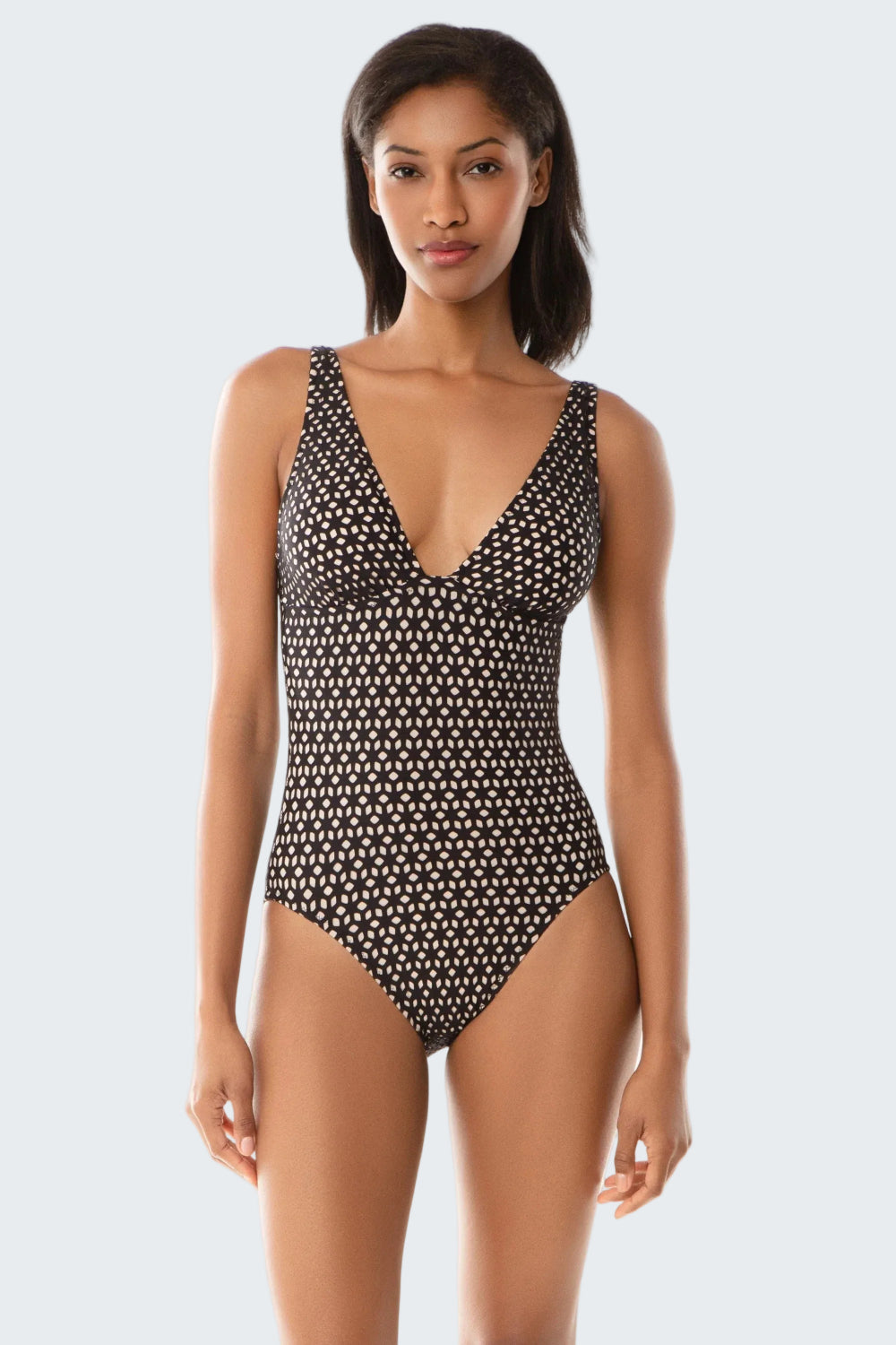 Woman wearing a black and white patterned swimsuit on a white background