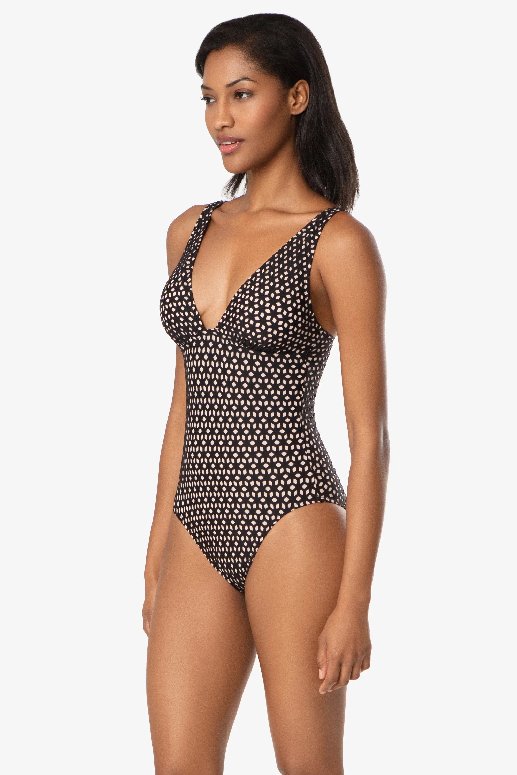 Woman wearing a black and white patterned swimsuit on a white background