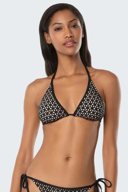 Woman wearing a black bikini with white polka dots on a white background