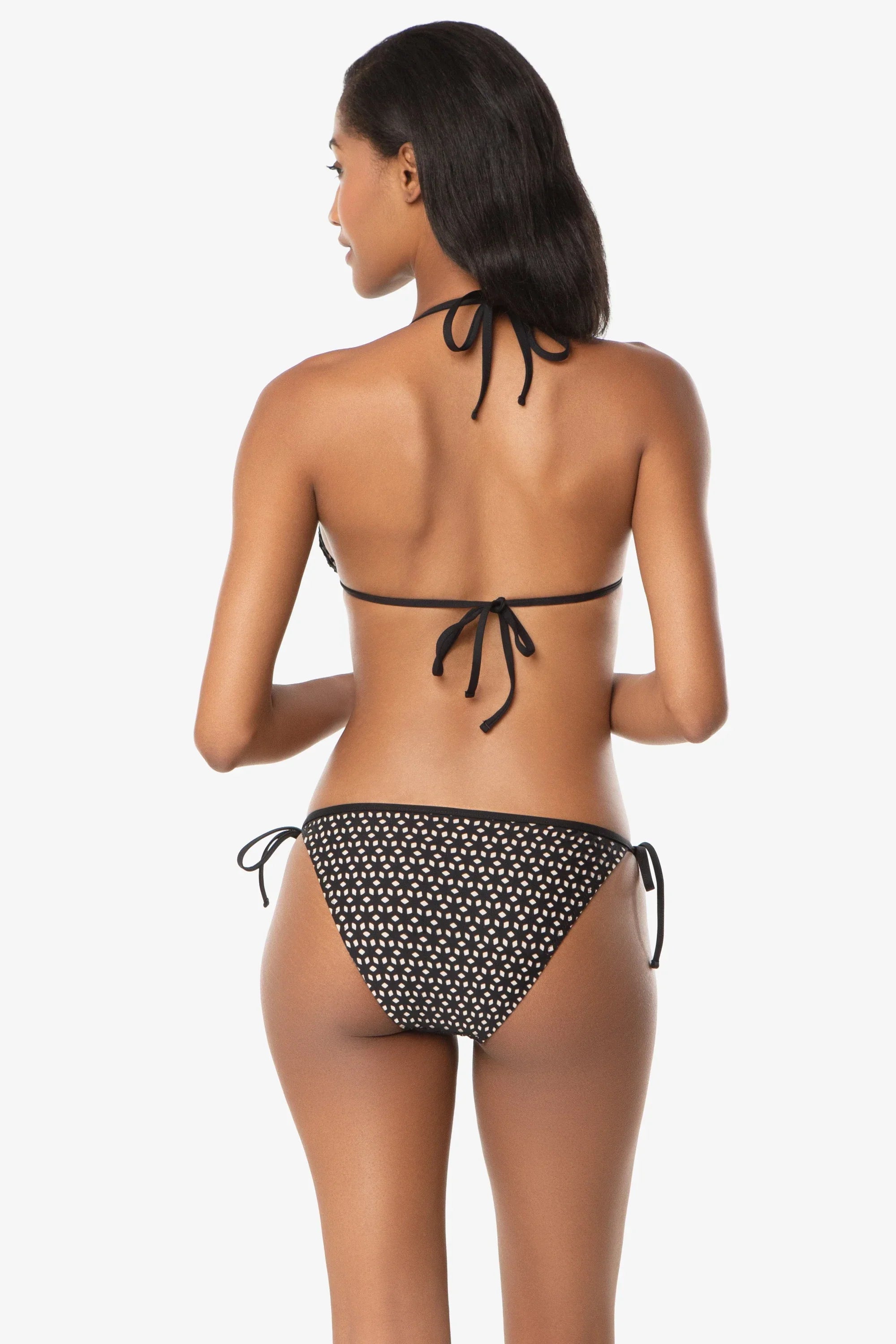 Woman wearing a black and white polka dot bikini on a white background