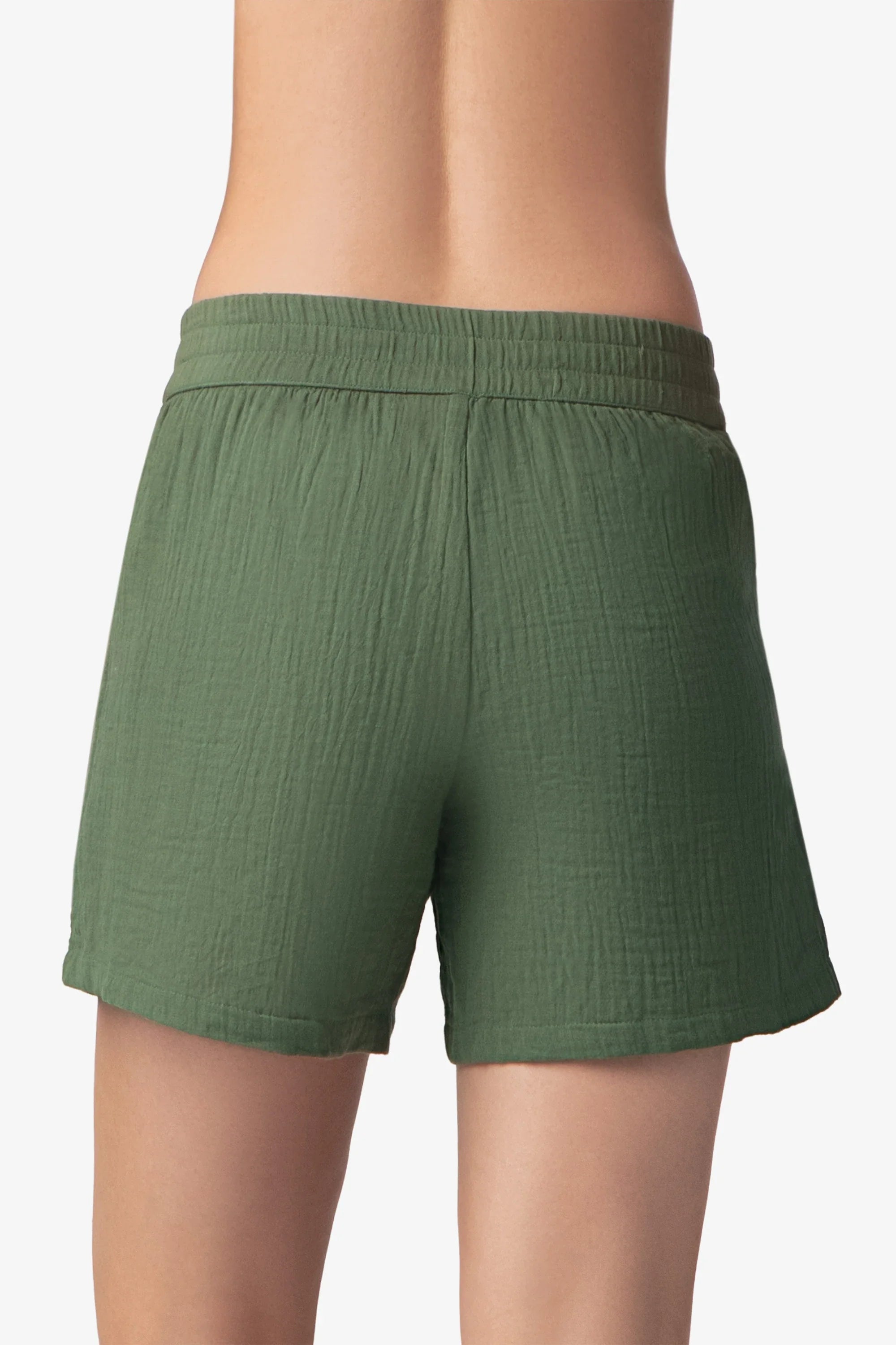 Green shorts worn by a person on a white background