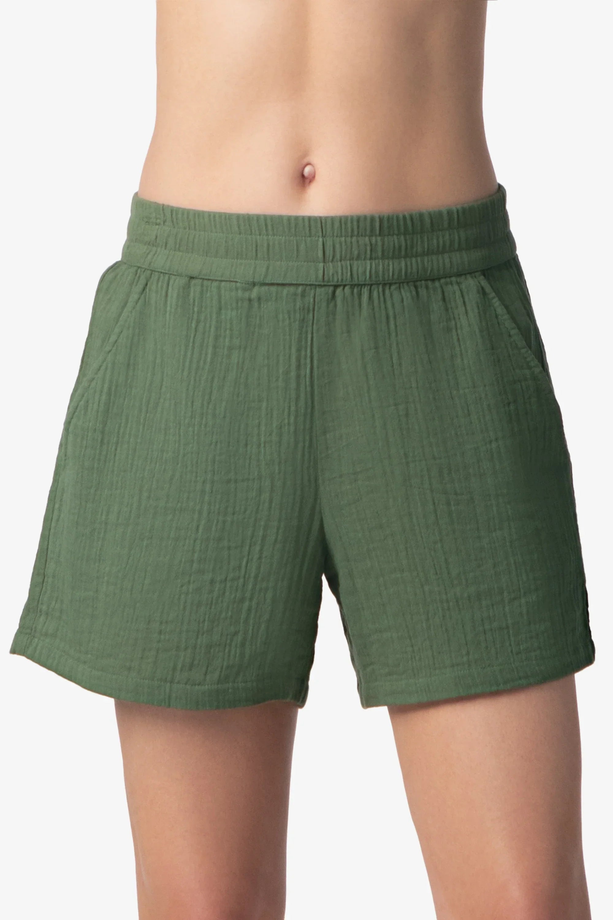 Green shorts worn by a person on a white background