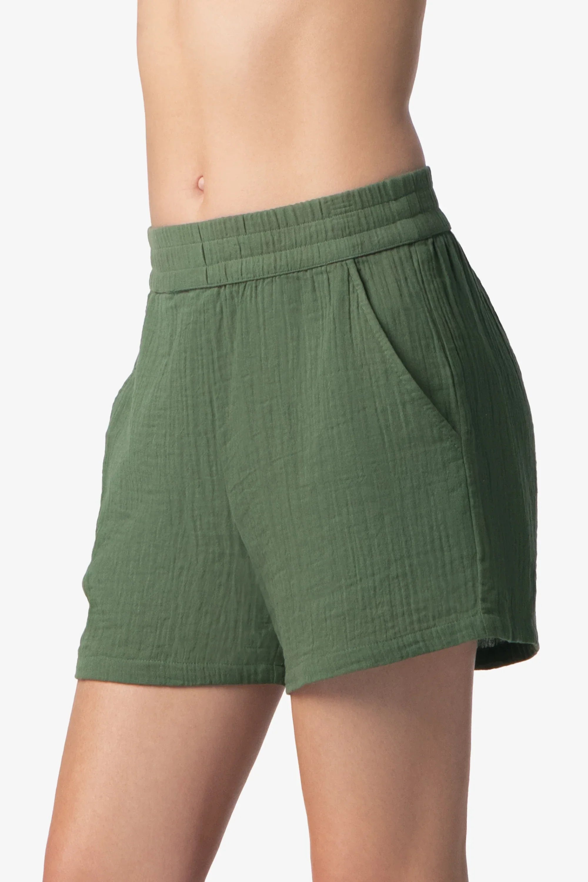 Green shorts worn by a person on a white background
