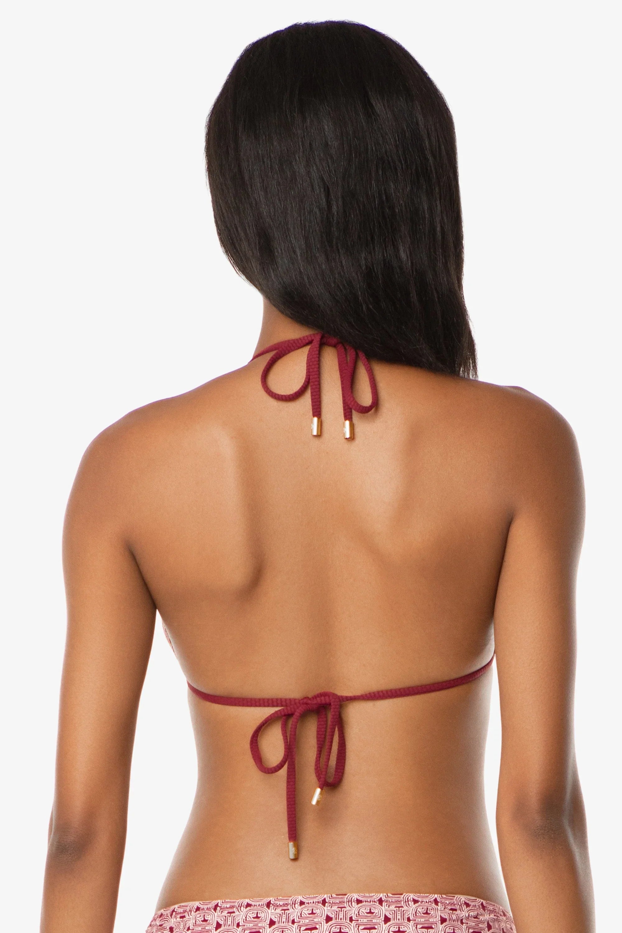 Woman wearing a red bikini top with thin straps on a white background