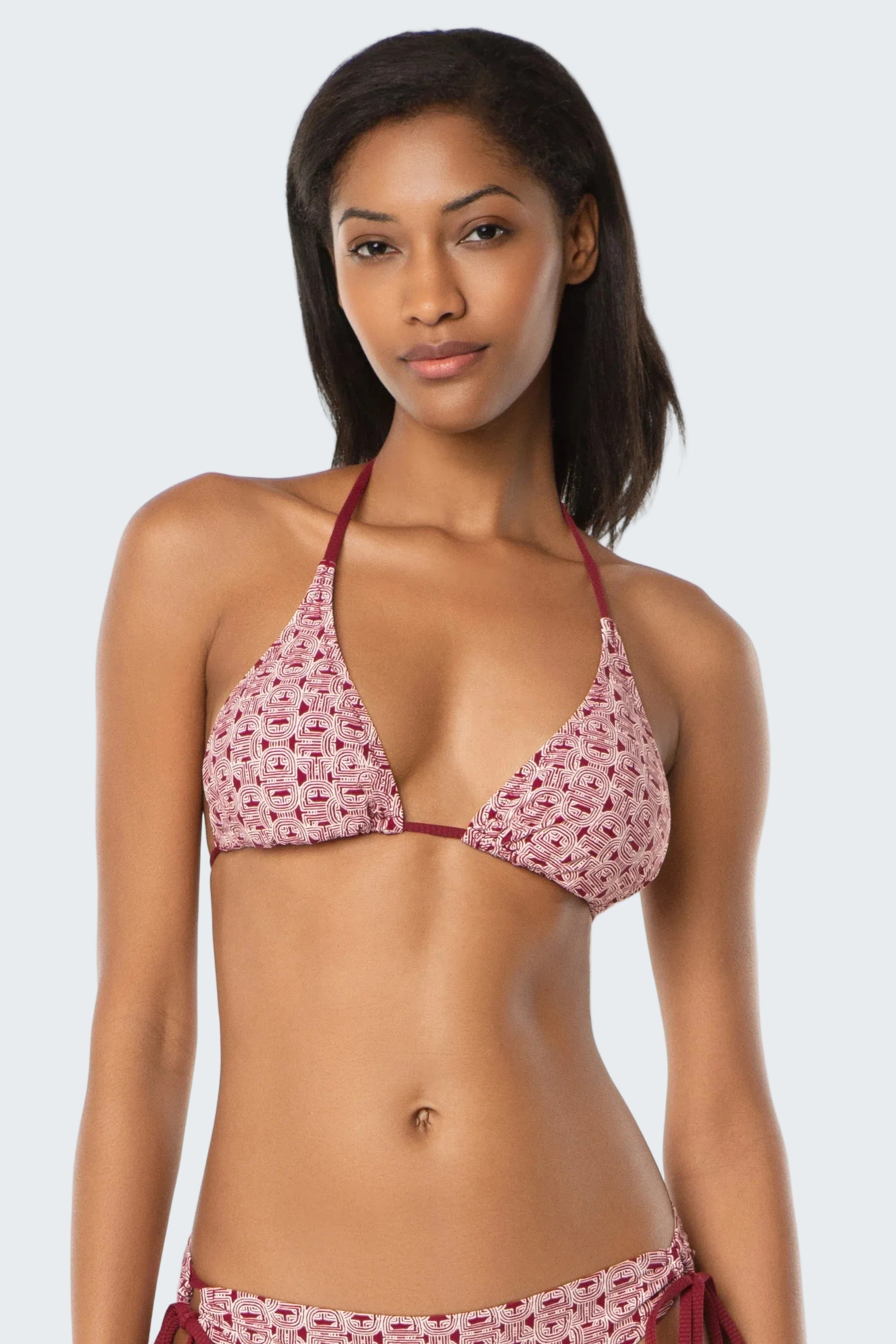 Woman wearing a red and white patterned bikini on a white background