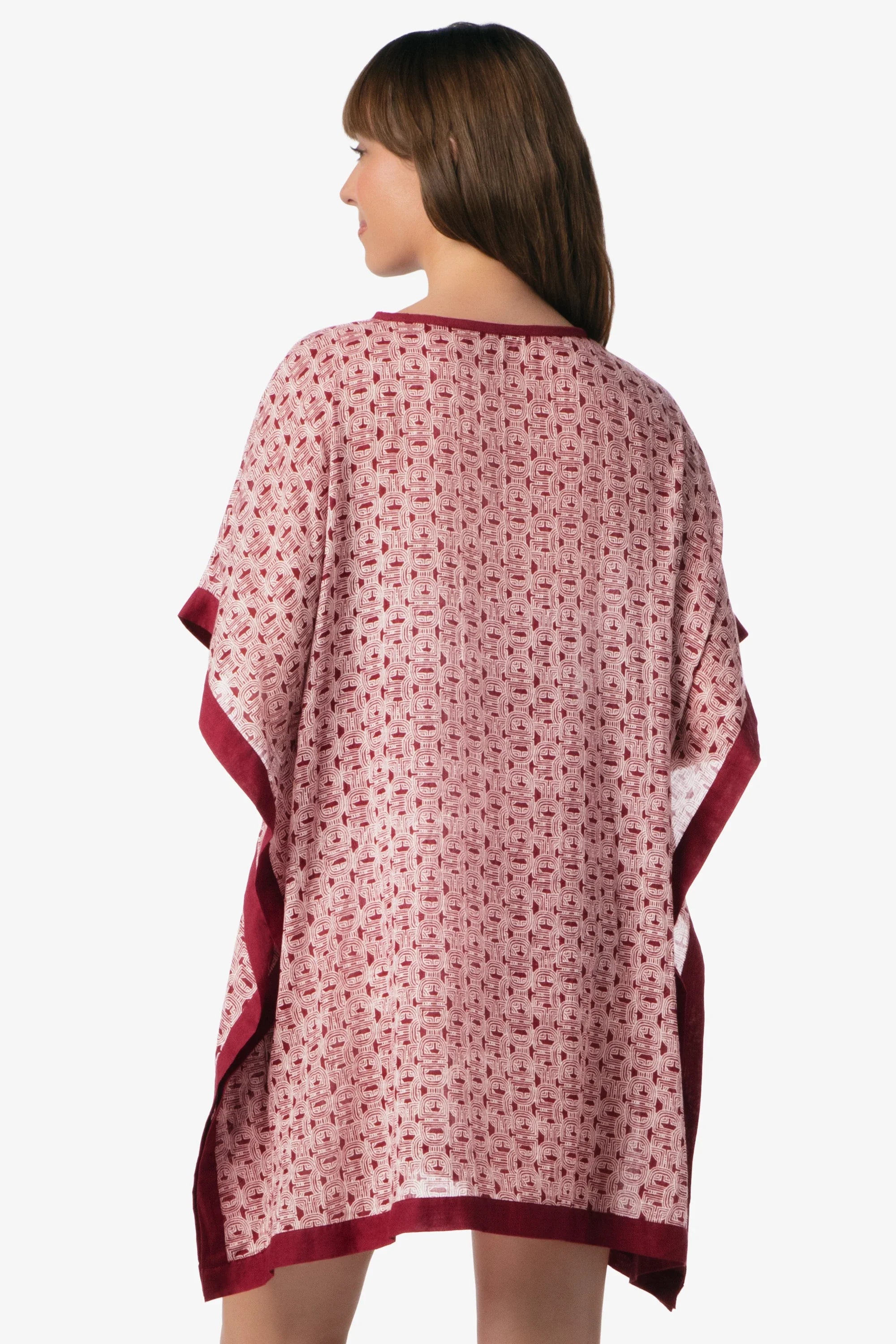 Woman wearing a pink and red patterned dress with a white background