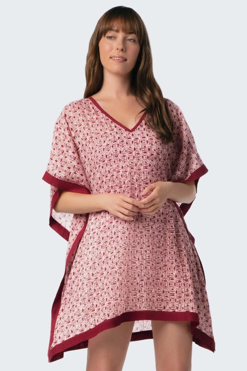 Woman wearing a pink and red patterned nightgown on a white background