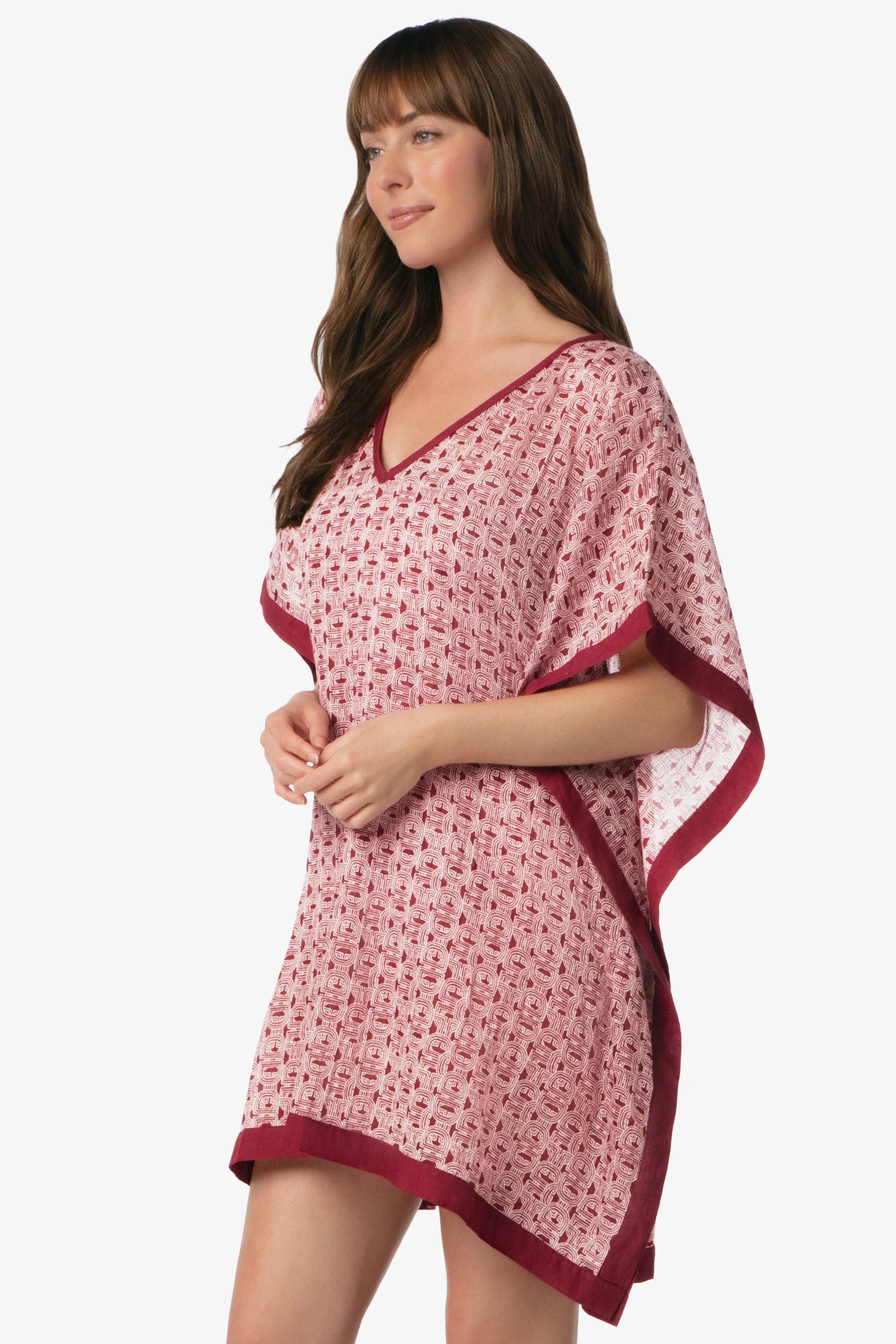 Woman wearing a pink floral dress with red trim on a white background