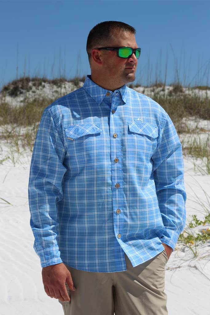 Man wearing a blue plaid shirt on a beach