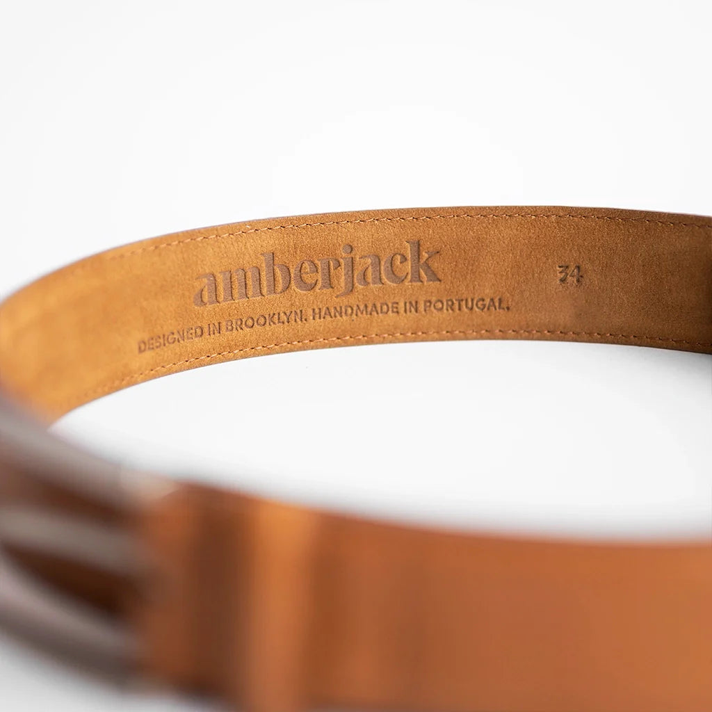 Brown leather belt with 'amberjack' branding on a white background