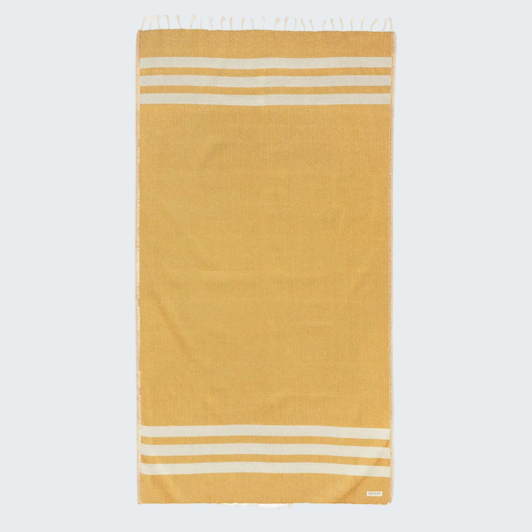 Mustard yellow towel with white stripes on a white background