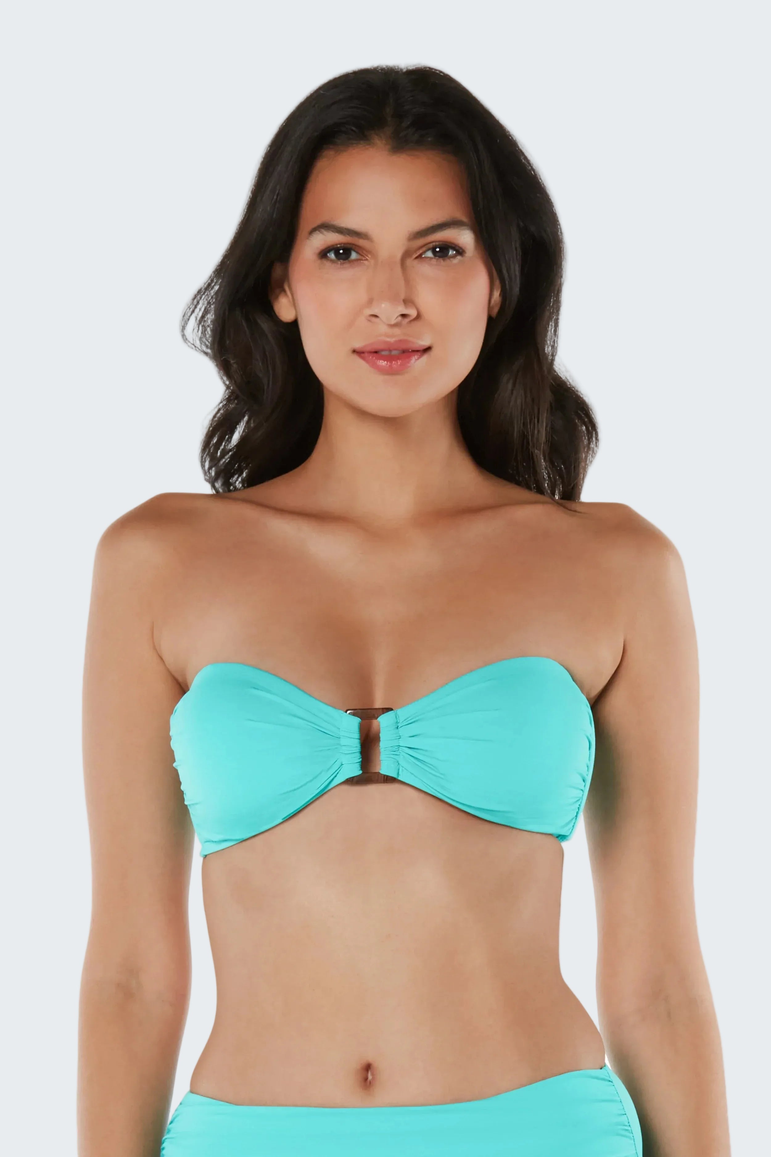 Woman wearing a turquoise strapless bikini against a white background