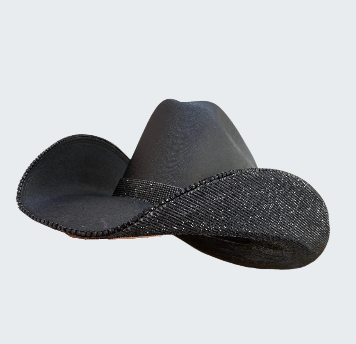 Black cowboy hat on a cardboard box with shelves in the background