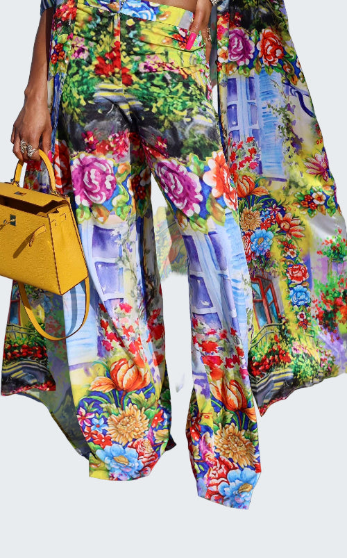 Colorful floral and architectural patterned pants with a yellow handbag.