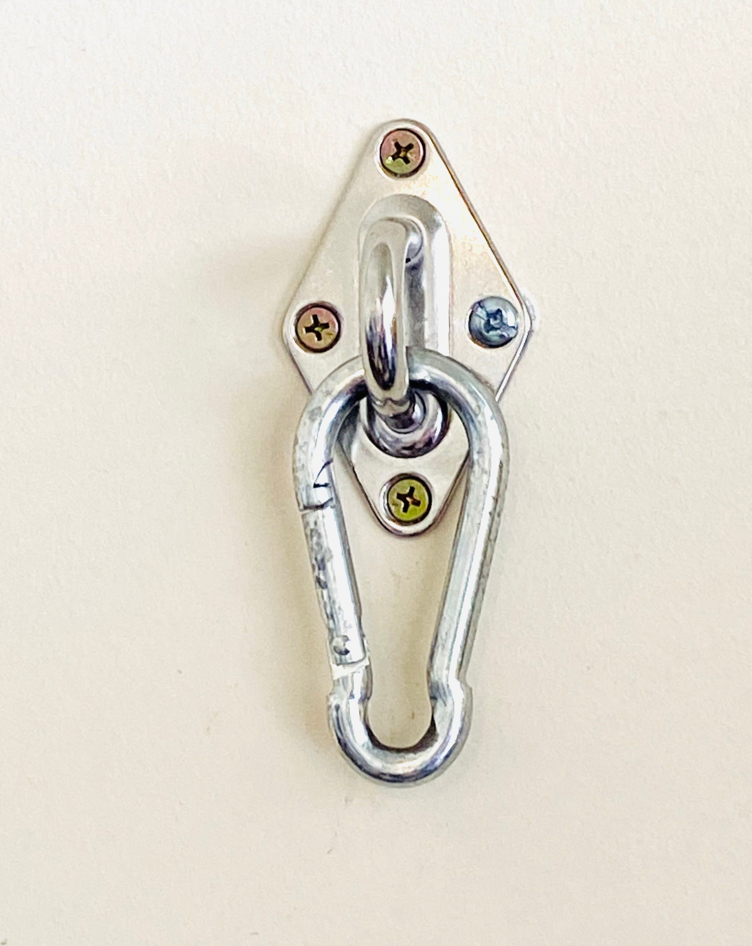 Metal carabiner with a shackle on a beige background