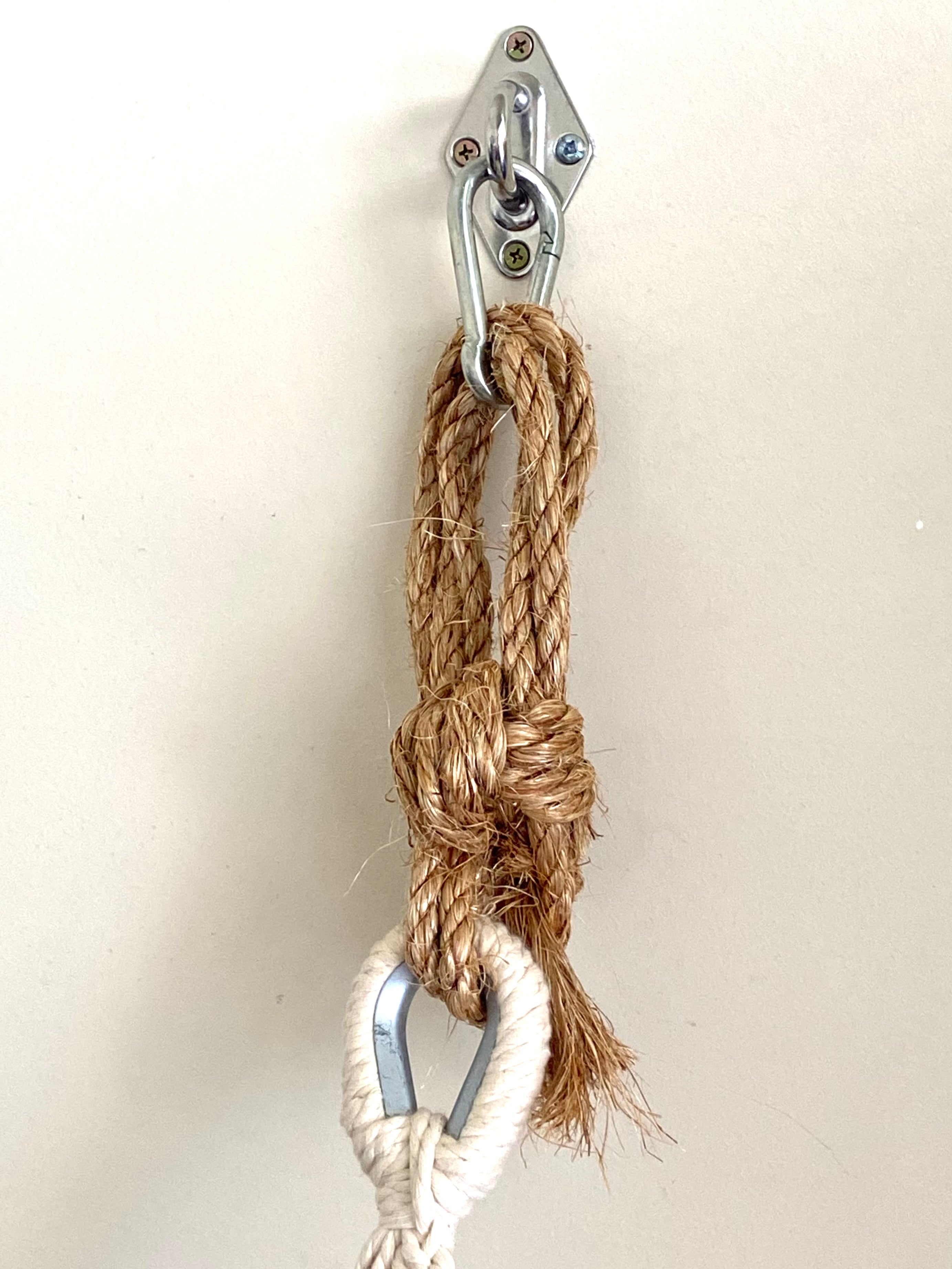 Metal carabiner with a rope tied around it on a white background