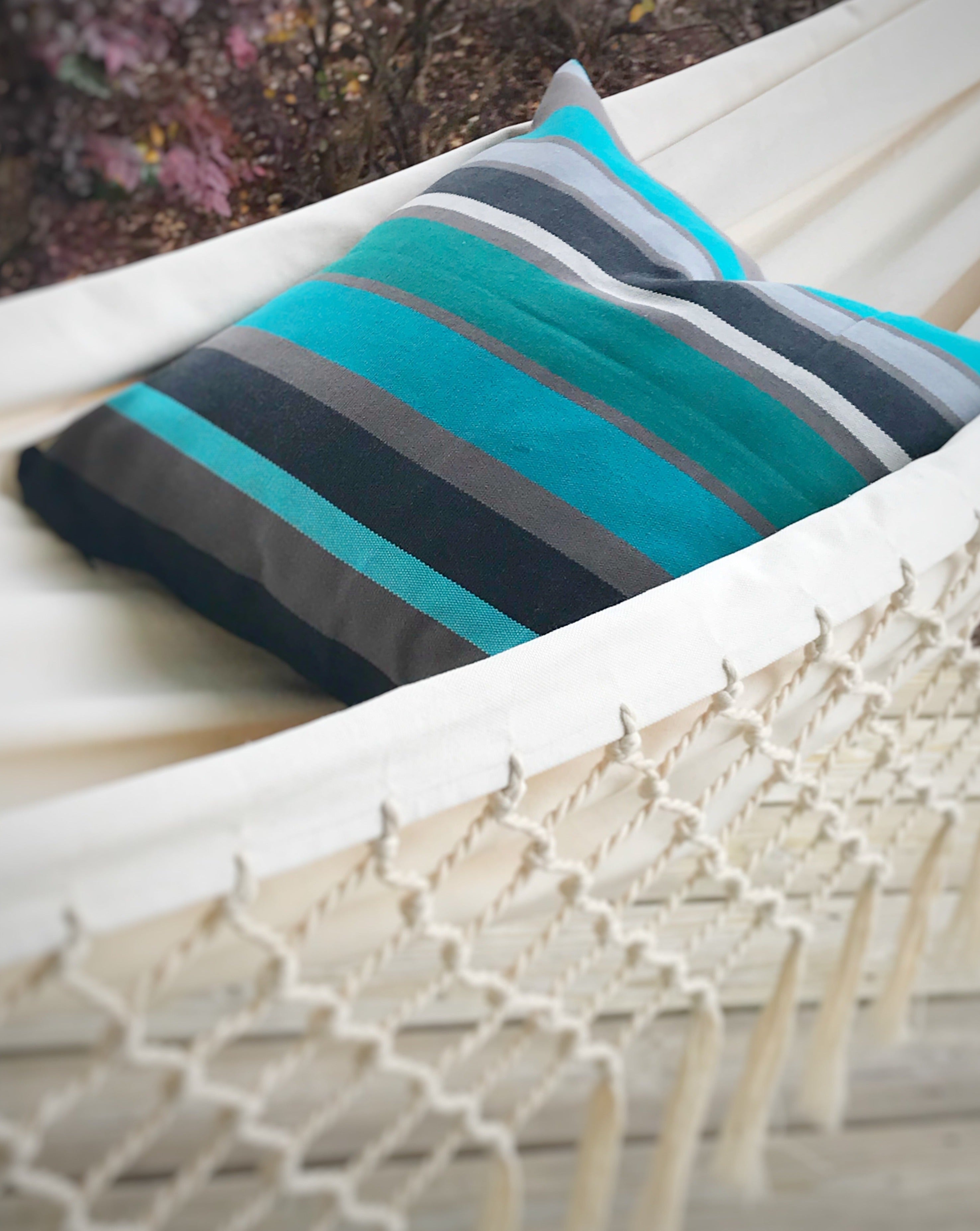 Striped pillow on a white hammock with blurred background
