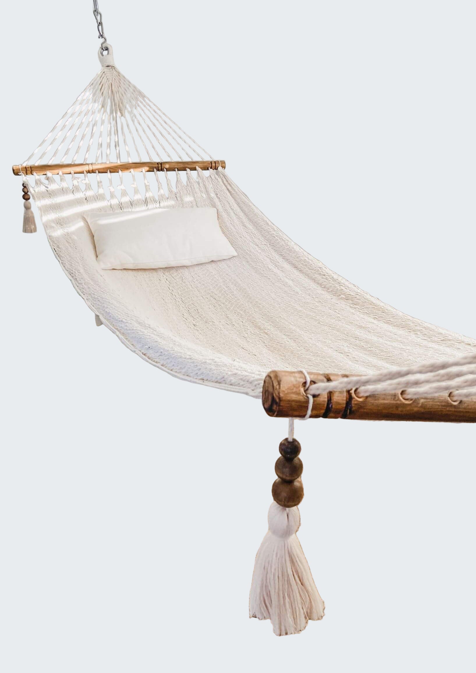 White hammock in a room with a textured rug and decorative elements.