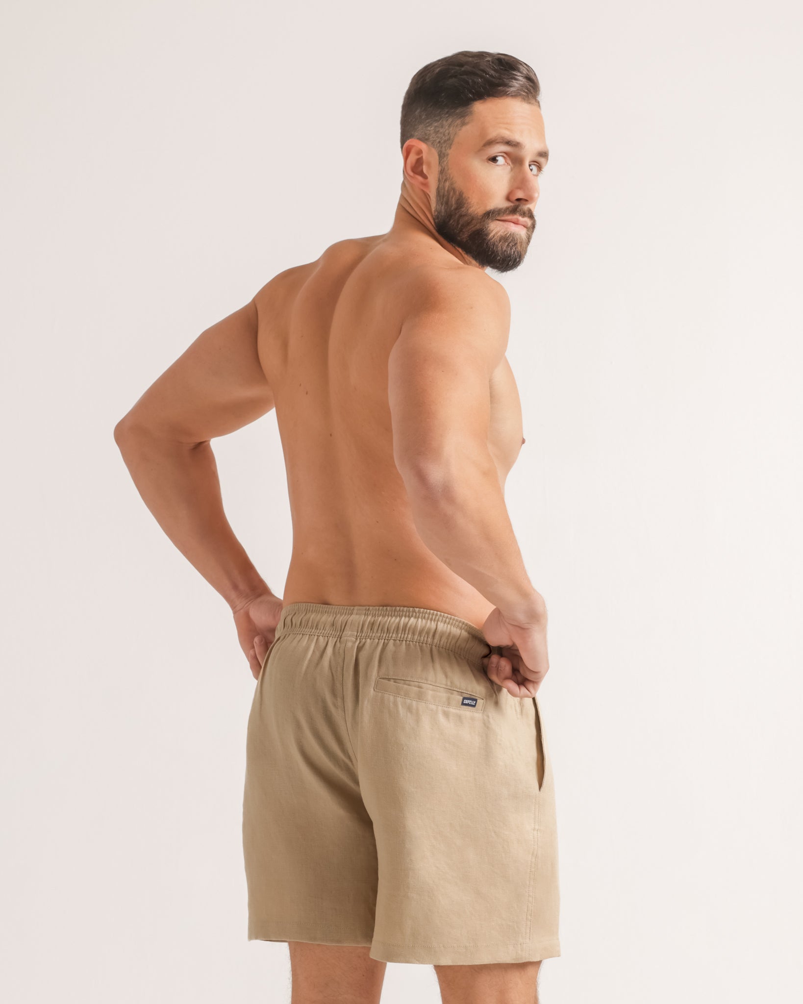 Man wearing beige boxer shorts on a plain background