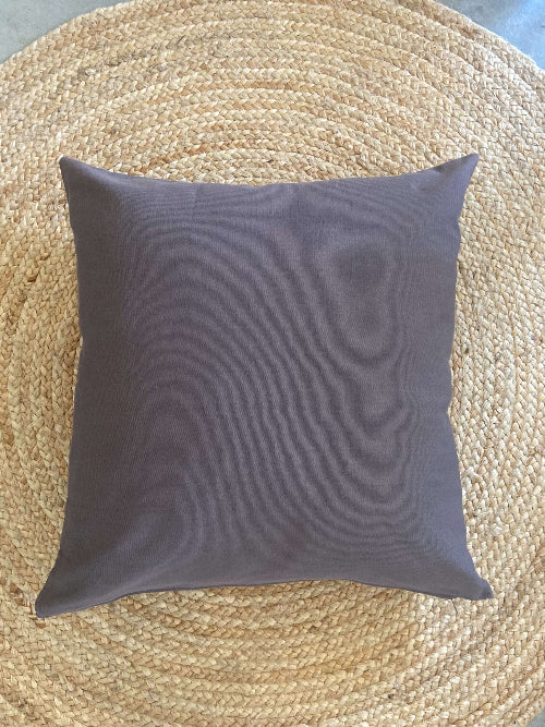 Gray pillow on a woven mat
