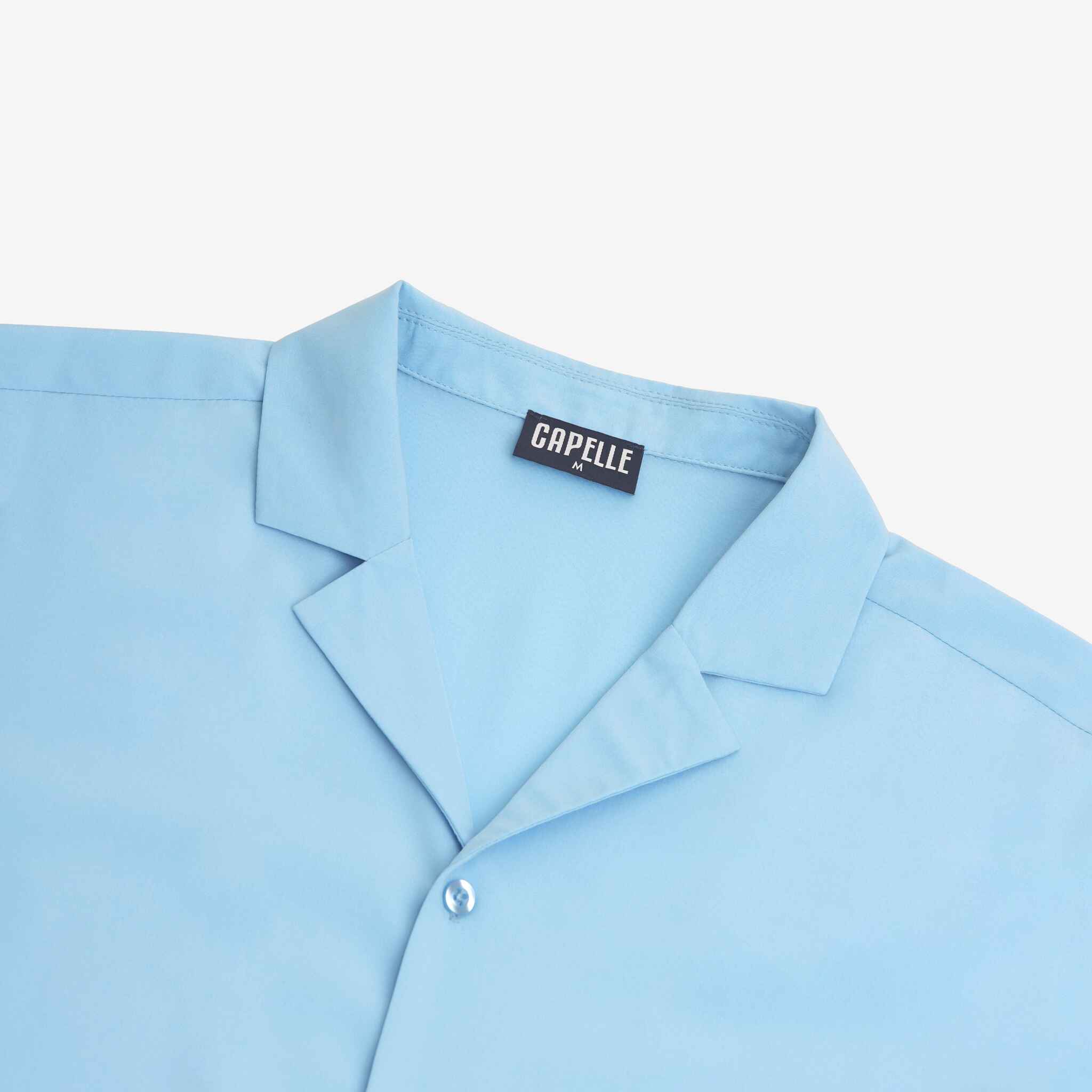 Light blue shirt with a visible brand label on a white background