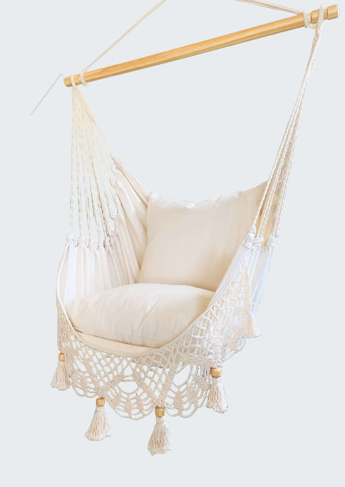 White hammock chair with wooden frame in a room with decorative elements.