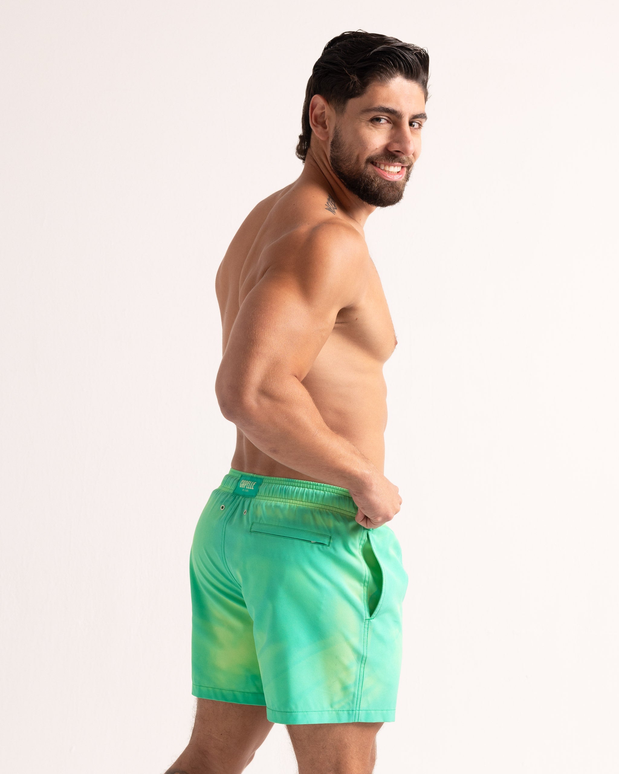 Man wearing green swim shorts on a white background