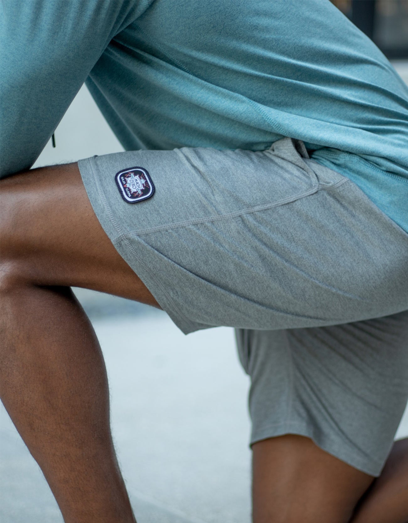 Person wearing gray shorts with a logo on a blurred background