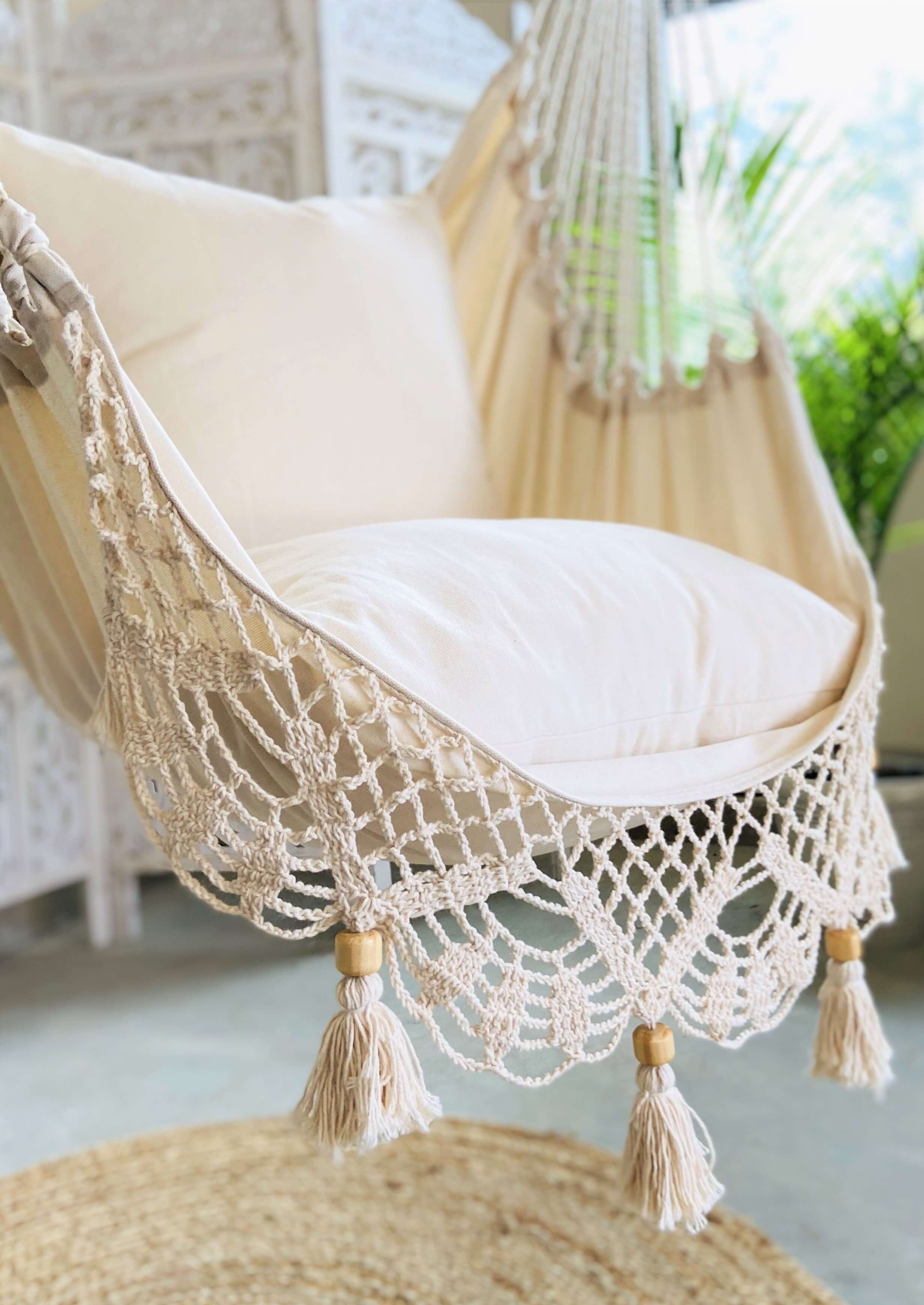 Decorative chair with macrame canopy and tassels in a bright room.