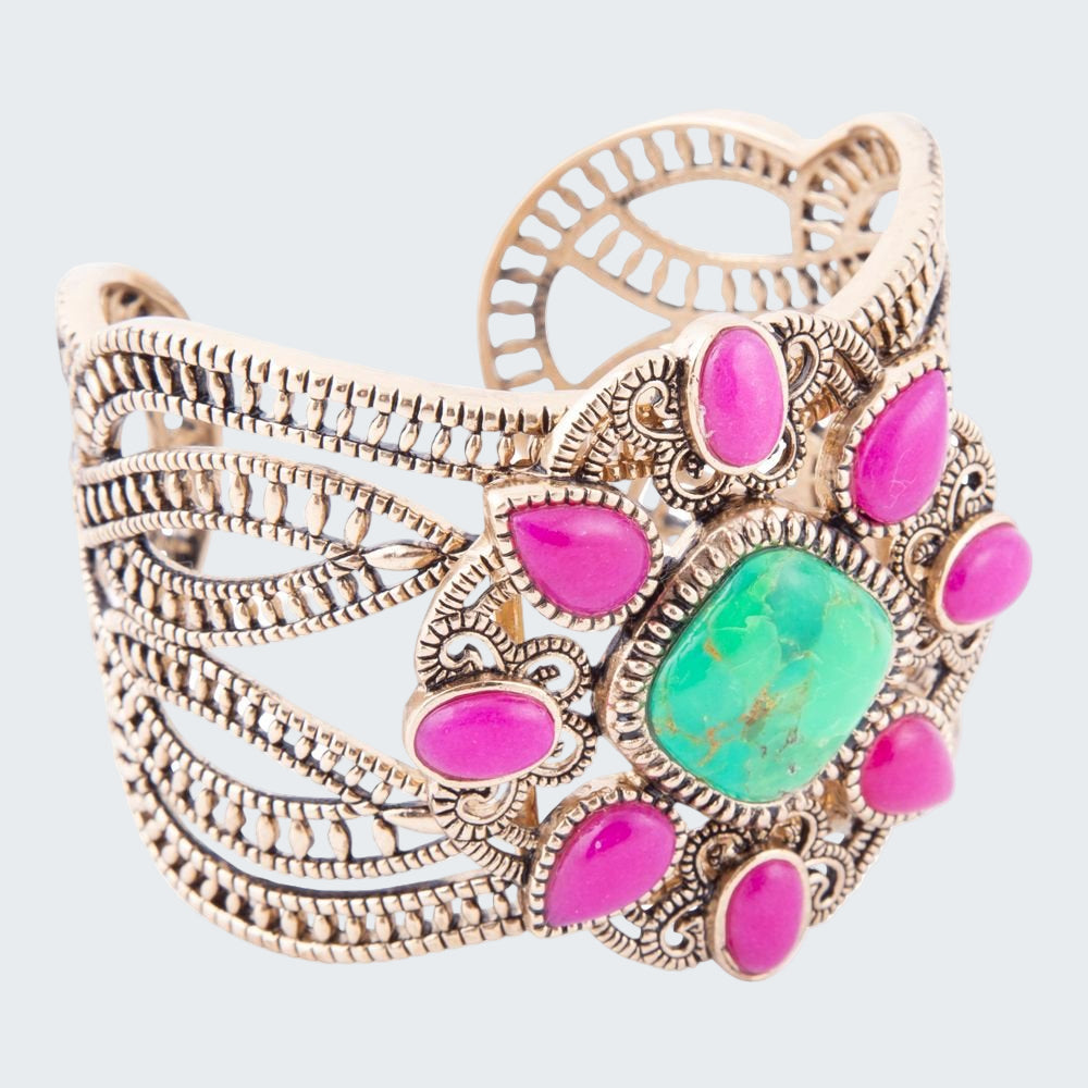 Decorative bracelet with pink and green stones on a white background