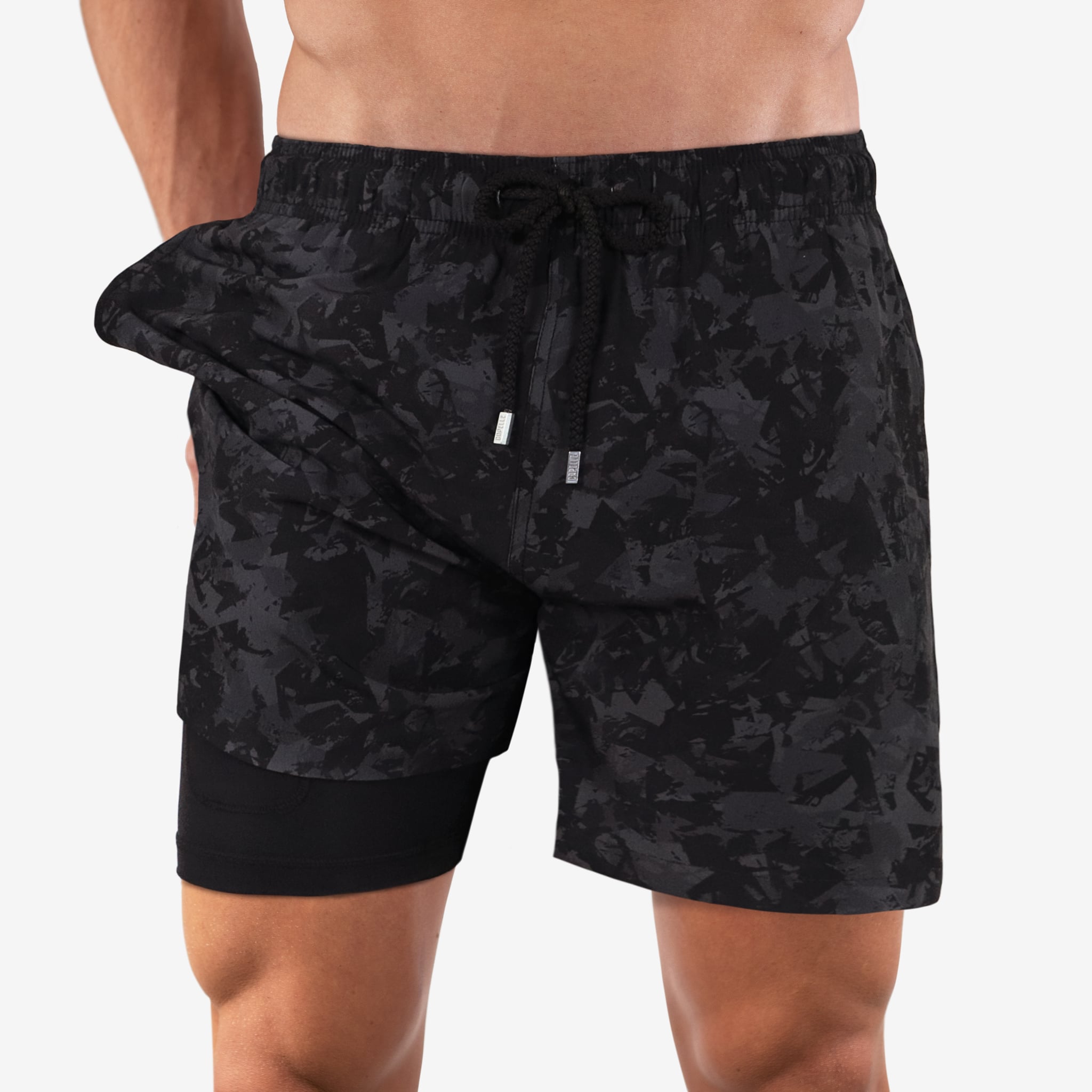 Black camouflage shorts worn by a person on a white background