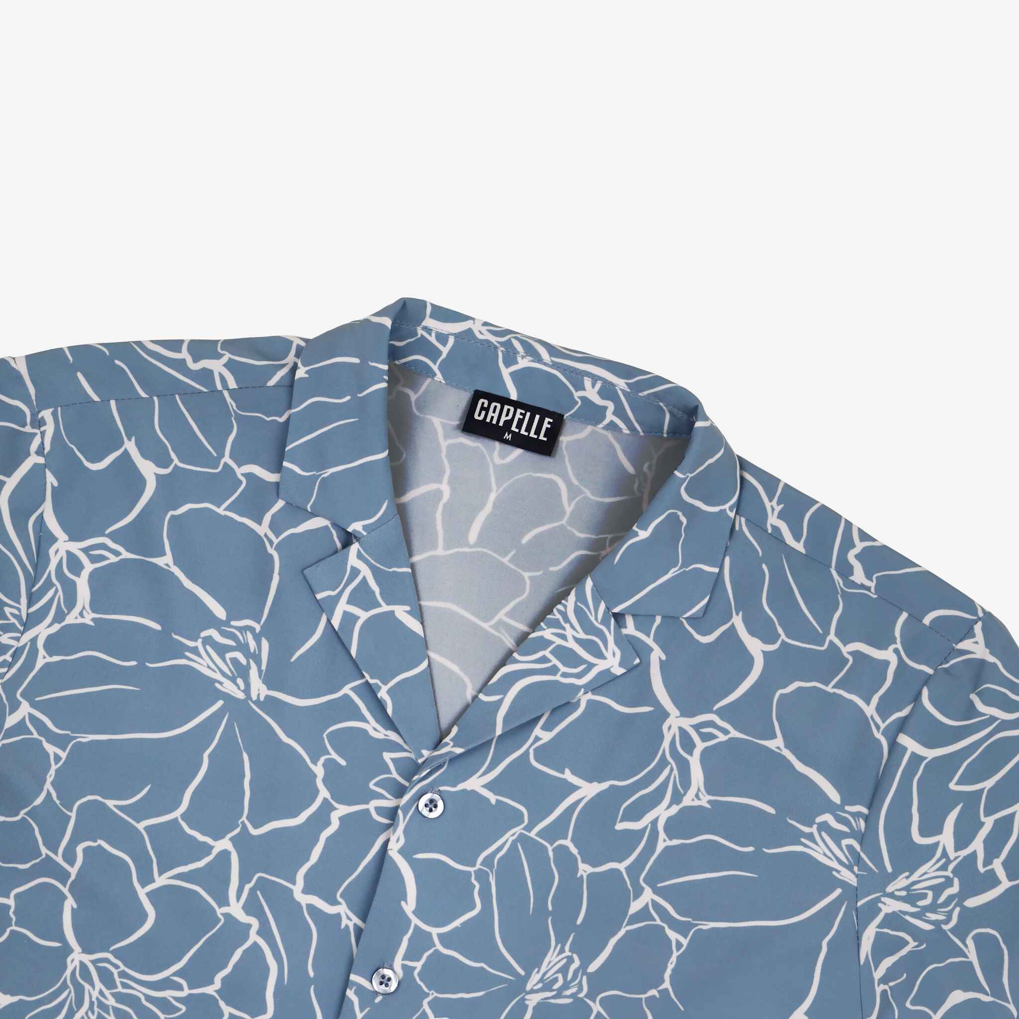 Blue floral patterned shirt with a visible brand label on a white background