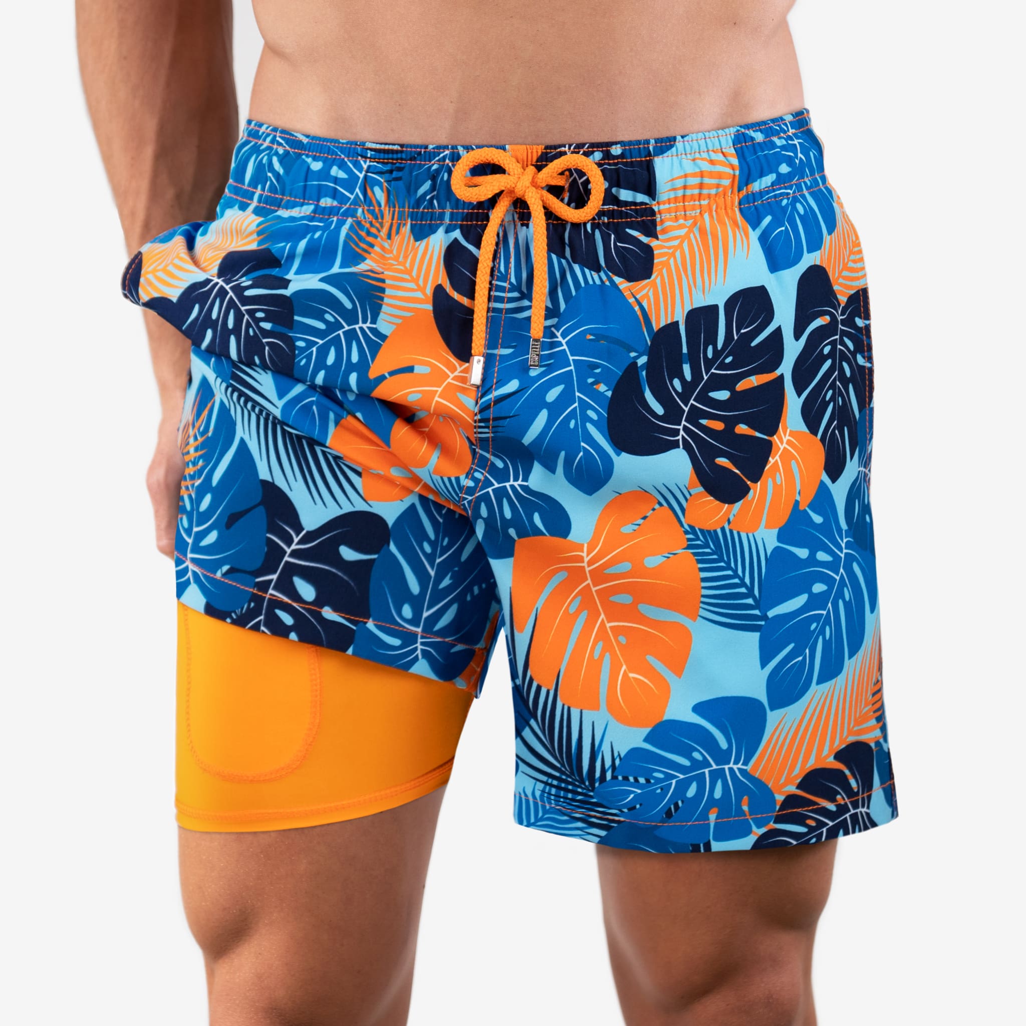 Colorful tropical leaf patterned swim shorts with orange drawstring on a white background