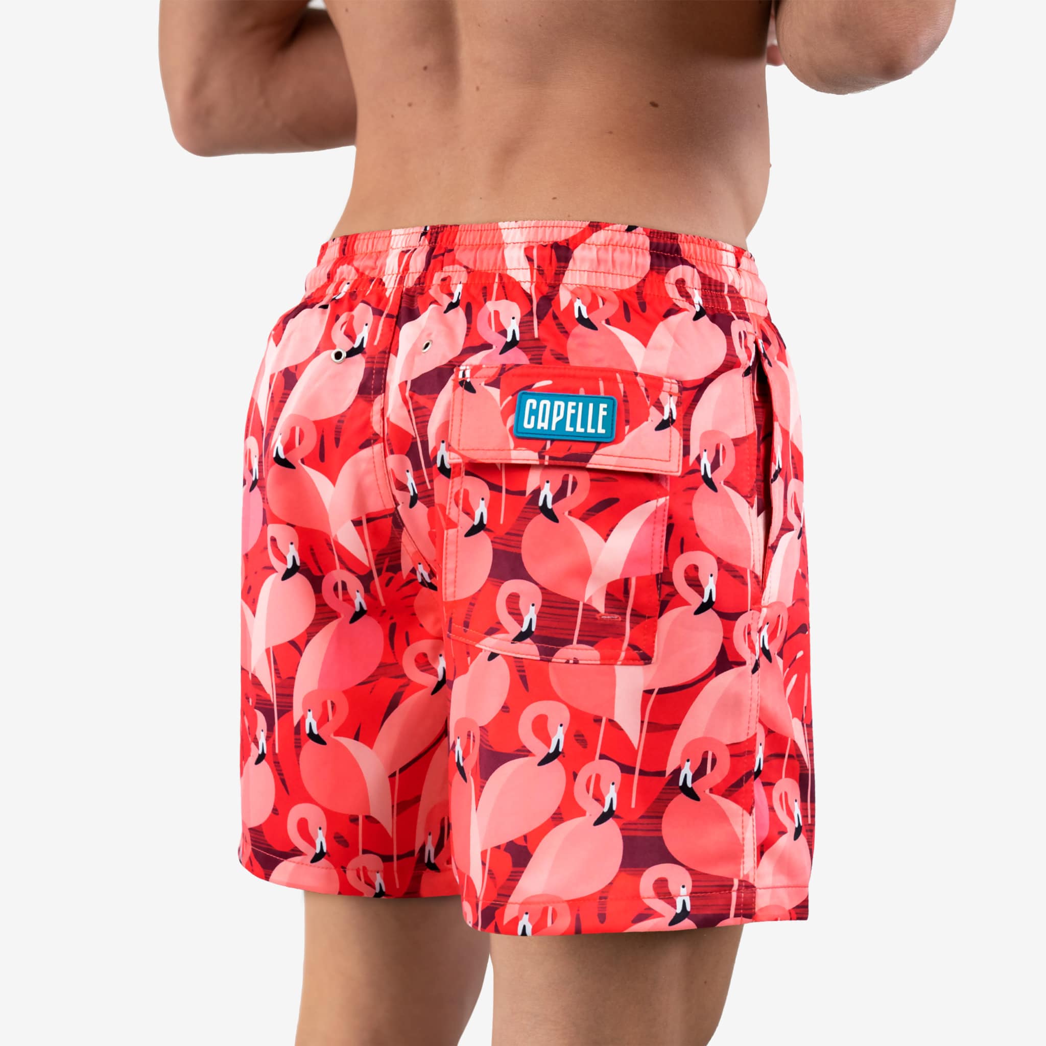 Red flamingo patterned swim shorts with a visible brand logo on a white background