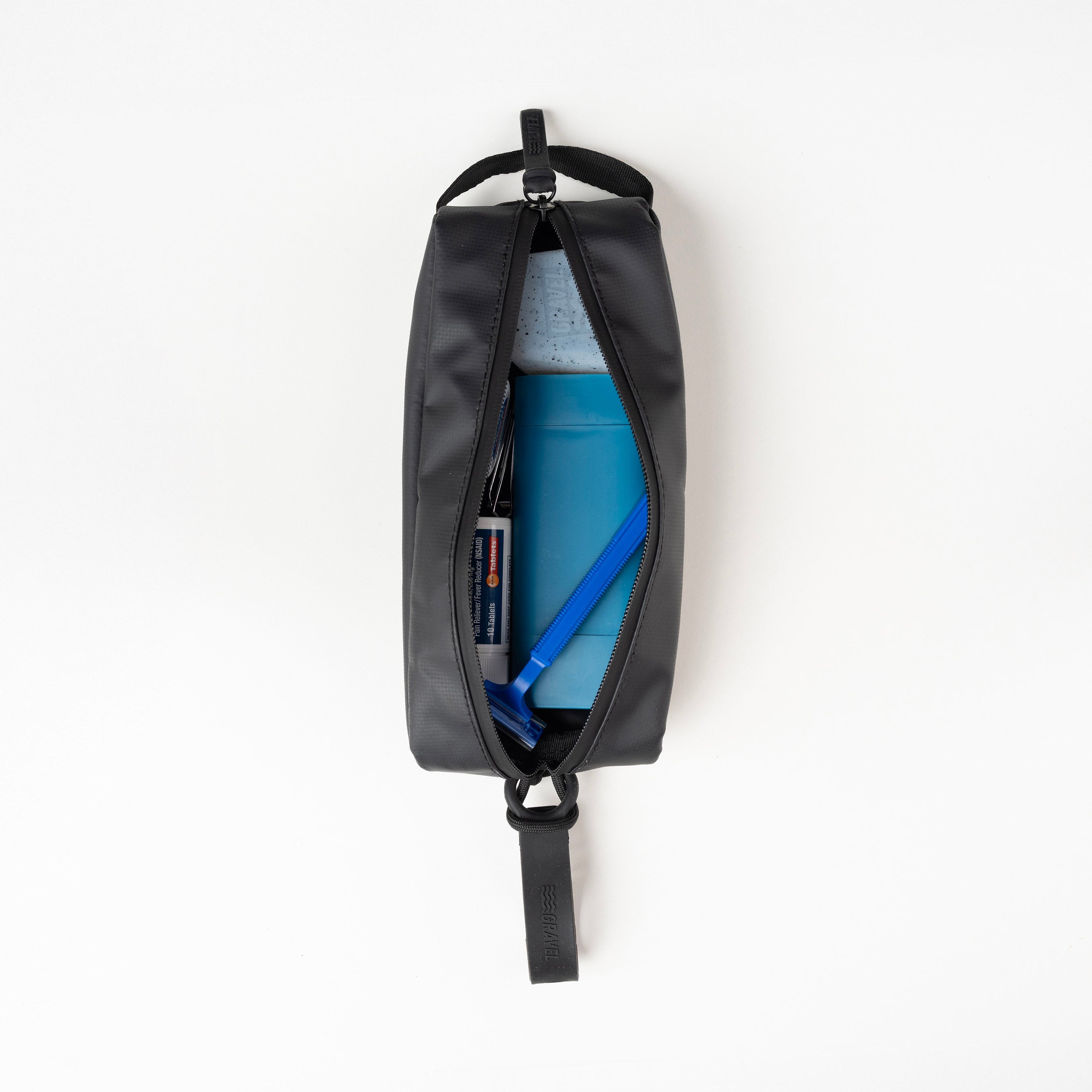 Black backpack with items inside on a white background