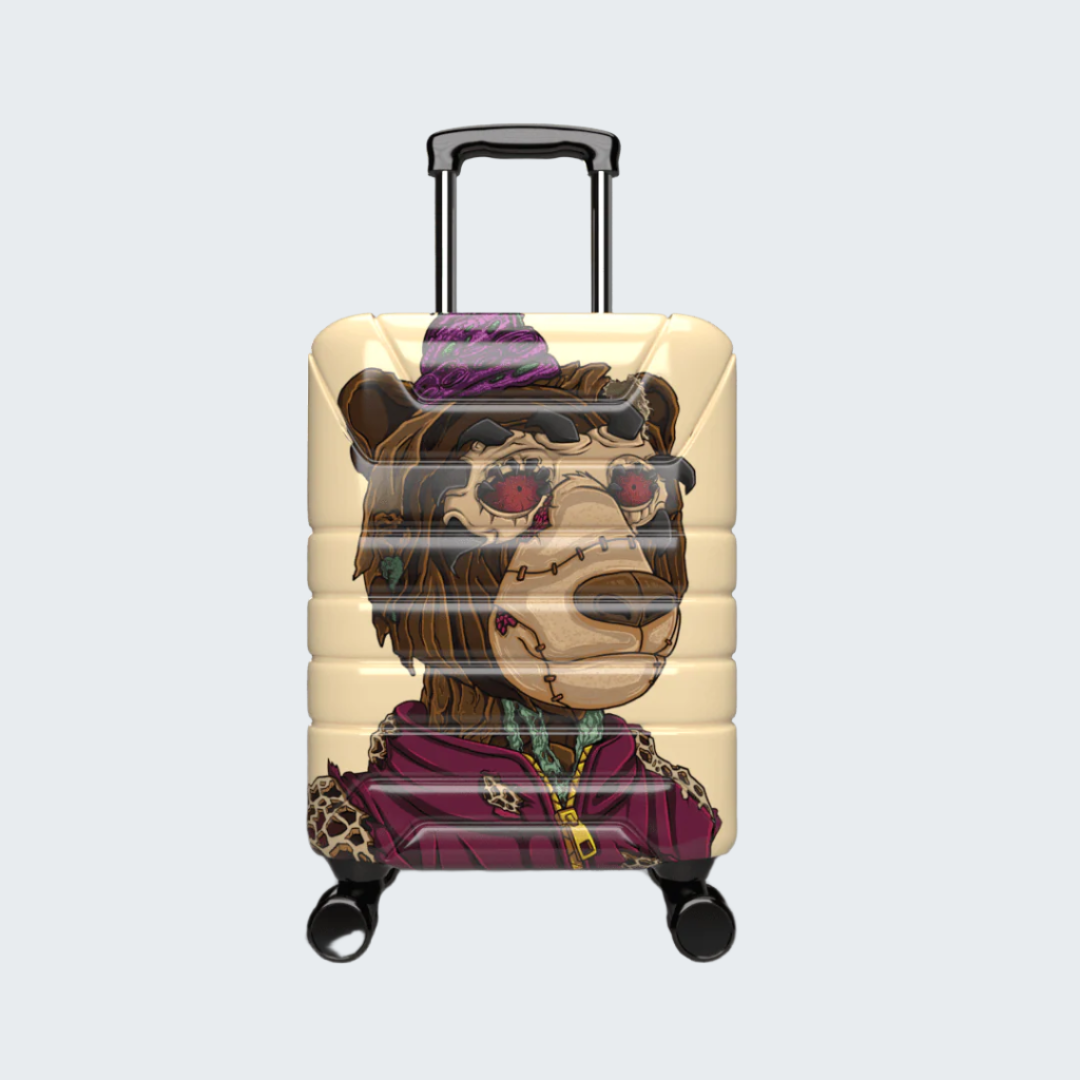 Beige suitcase with a cartoon bear design wearing sunglasses and a purple scarf on a black background