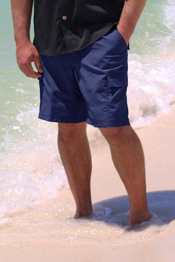 Person wearing blue shorts standing in shallow water on a beach