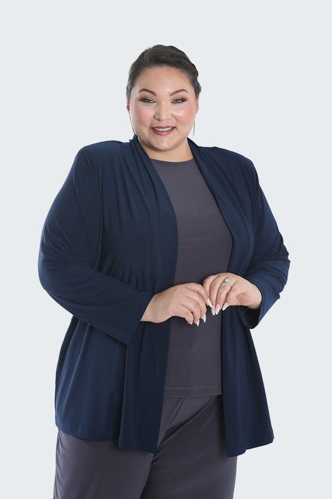 Woman wearing a navy blue cardigan over a dark top on a white background