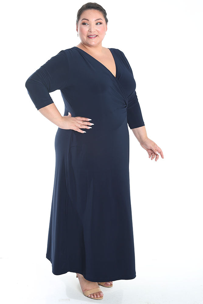 Woman wearing a navy blue dress with a V-neck and three-quarter sleeves on a white background