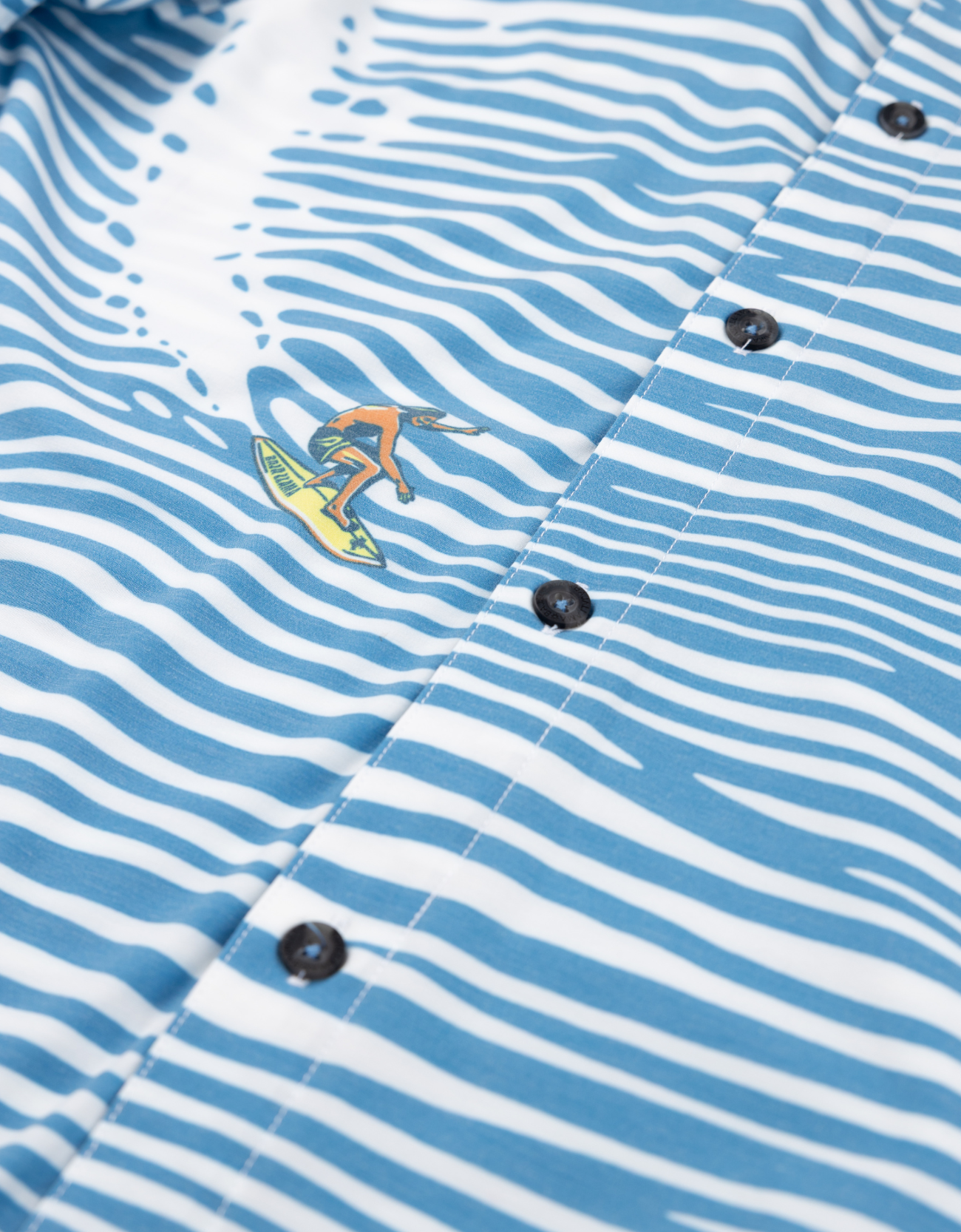 Close-up of a blue and white striped shirt with a small embroidered design on the chest.