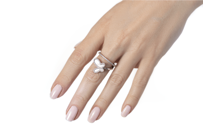 Hand wearing a butterfly-shaped ring on a white background